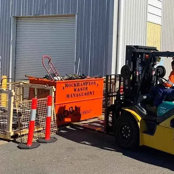 Forklift Moving An Orange Waste Container — Bob’s Trailer Trash In Rockhampton, QLD