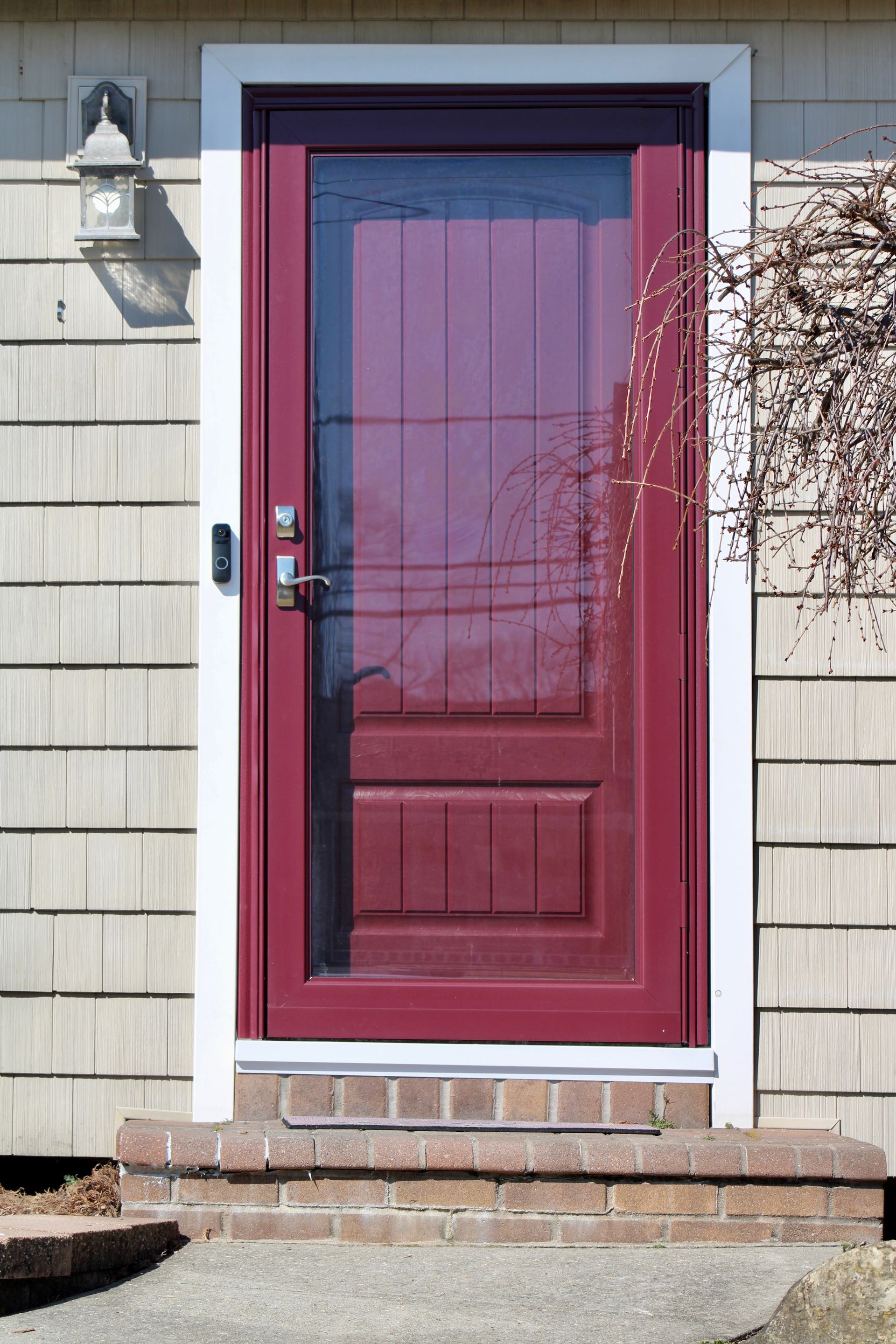 A red door is on the side of a house