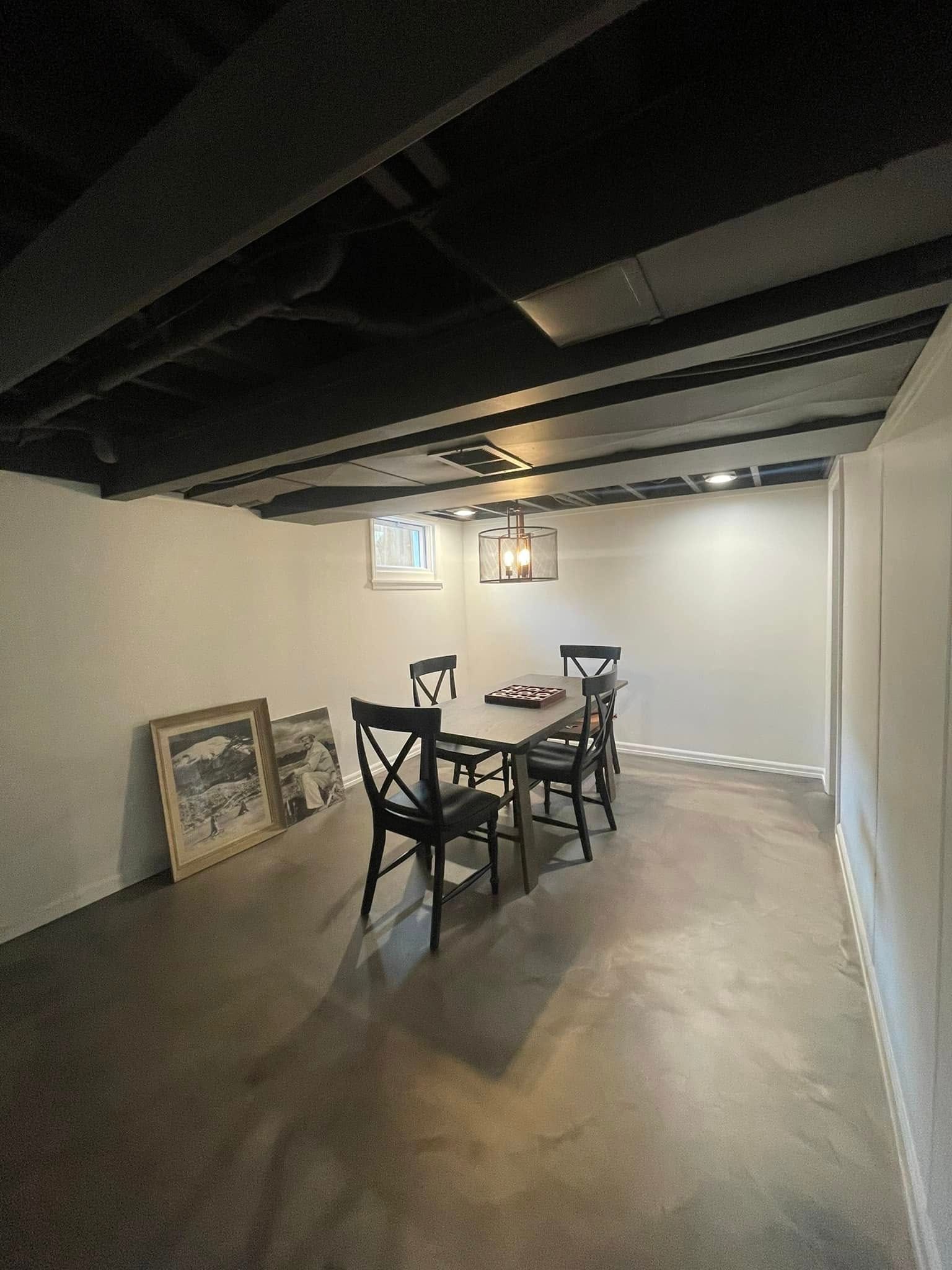 A dining room in a basement with a table and chairs.