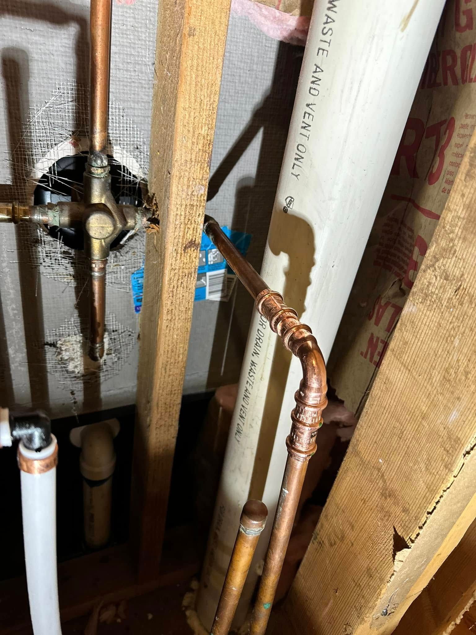 A close up of a copper pipe in a bathroom.