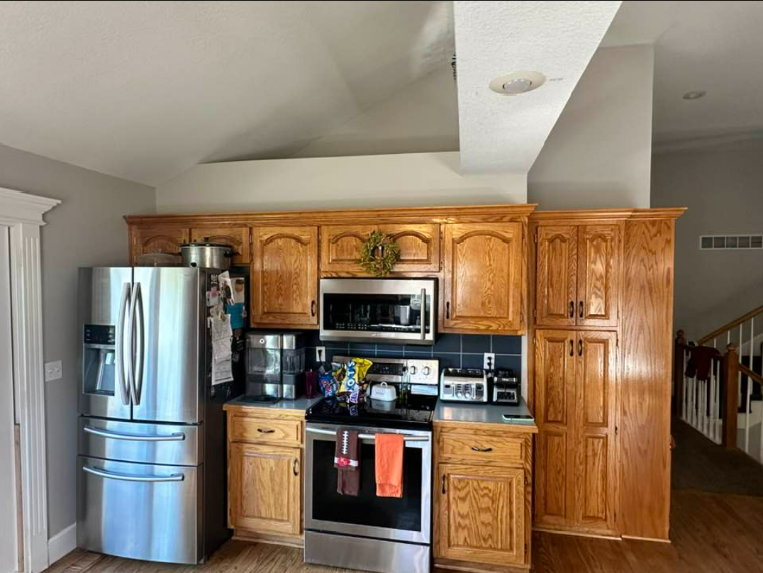 A kitchen with stainless steel appliances and wooden cabinets