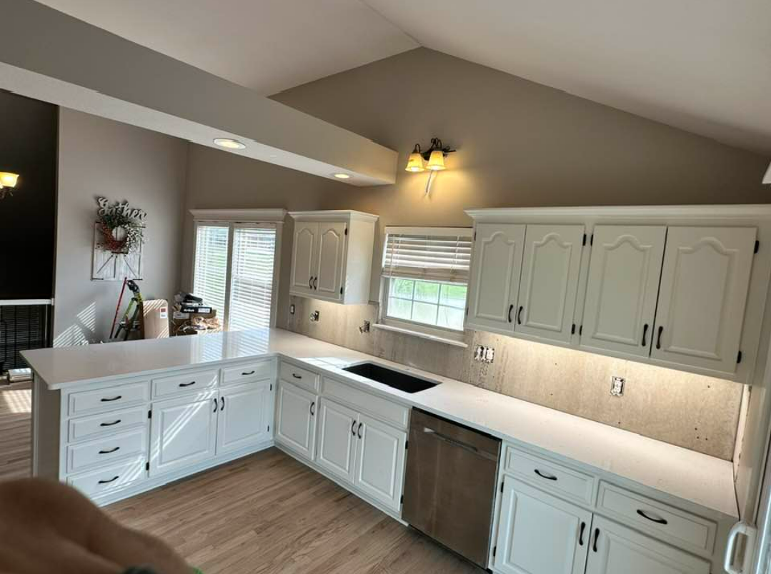 A kitchen with white cabinets and stainless steel appliances.