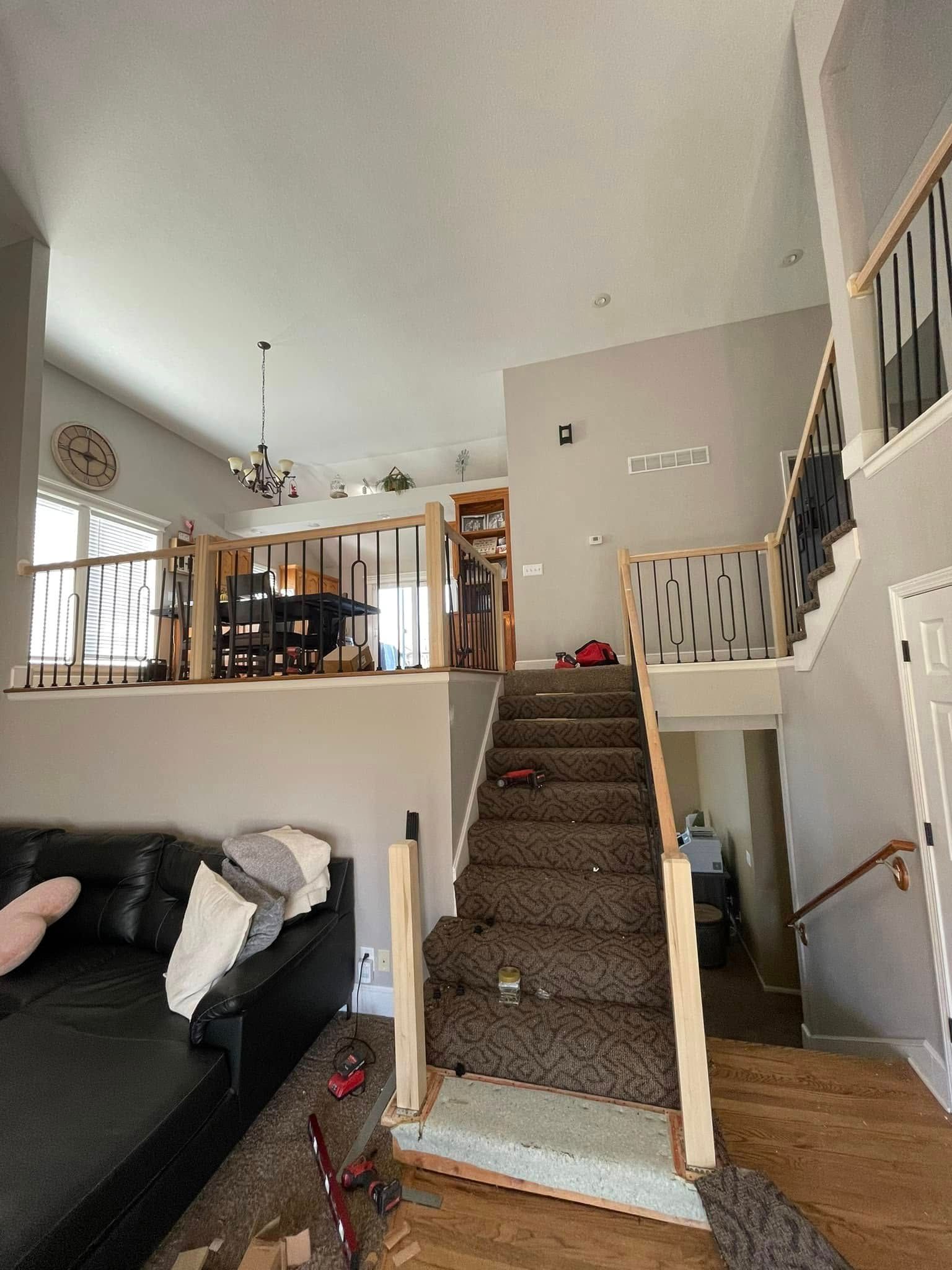 A living room with stairs leading up to the second floor.