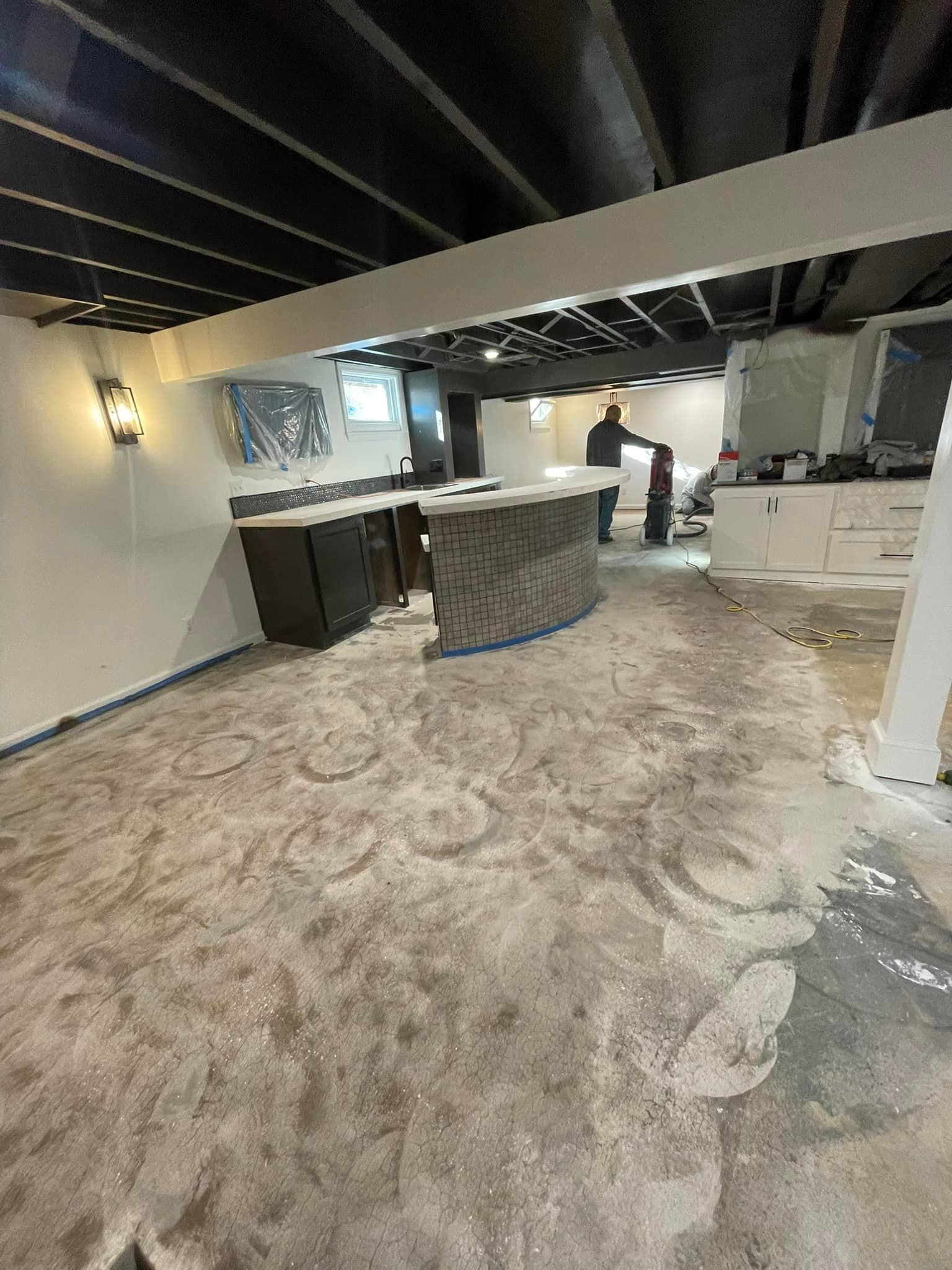 A basement with a concrete floor and a bar.
