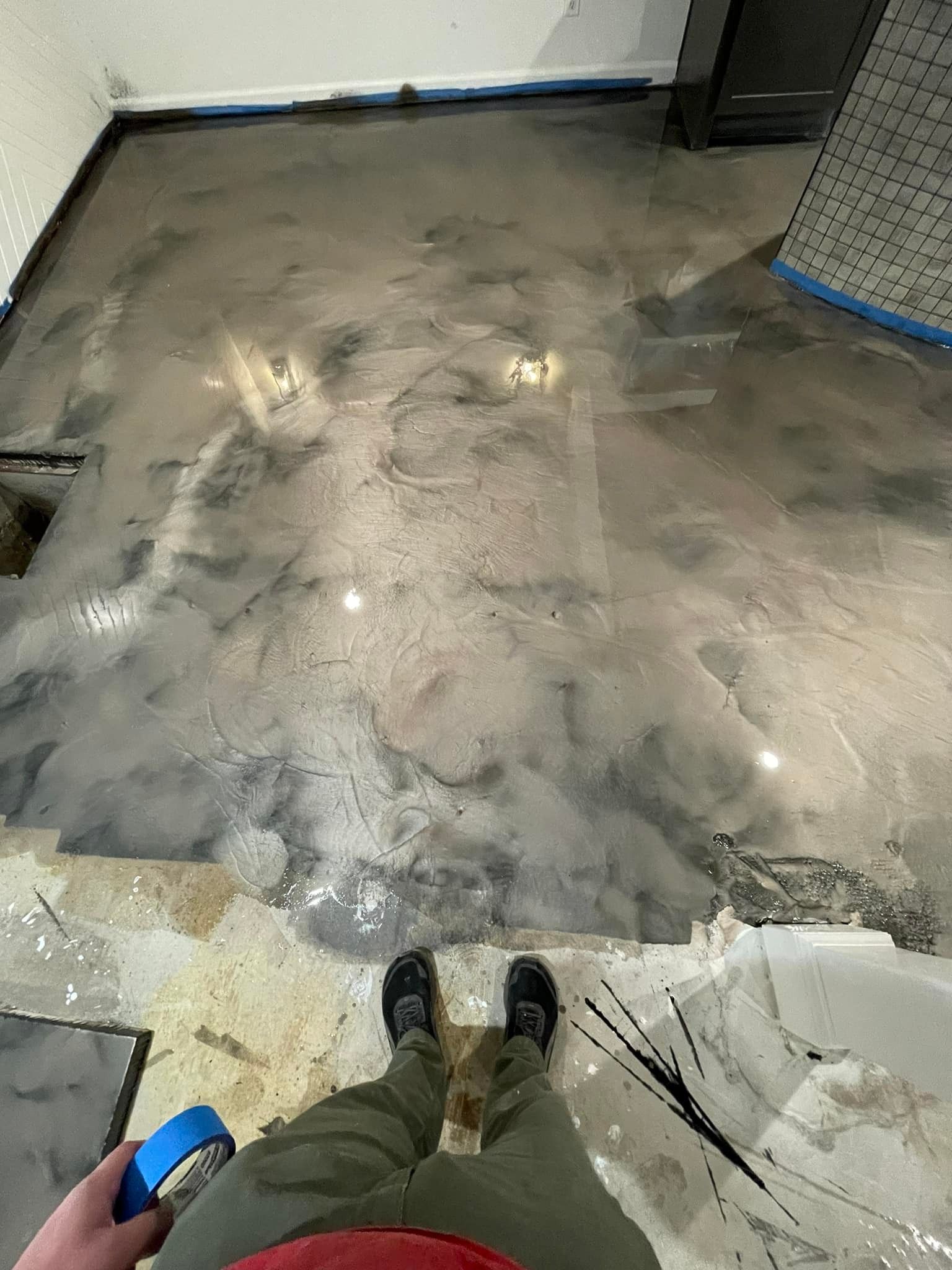 A person is standing on a shiny metallic floor.