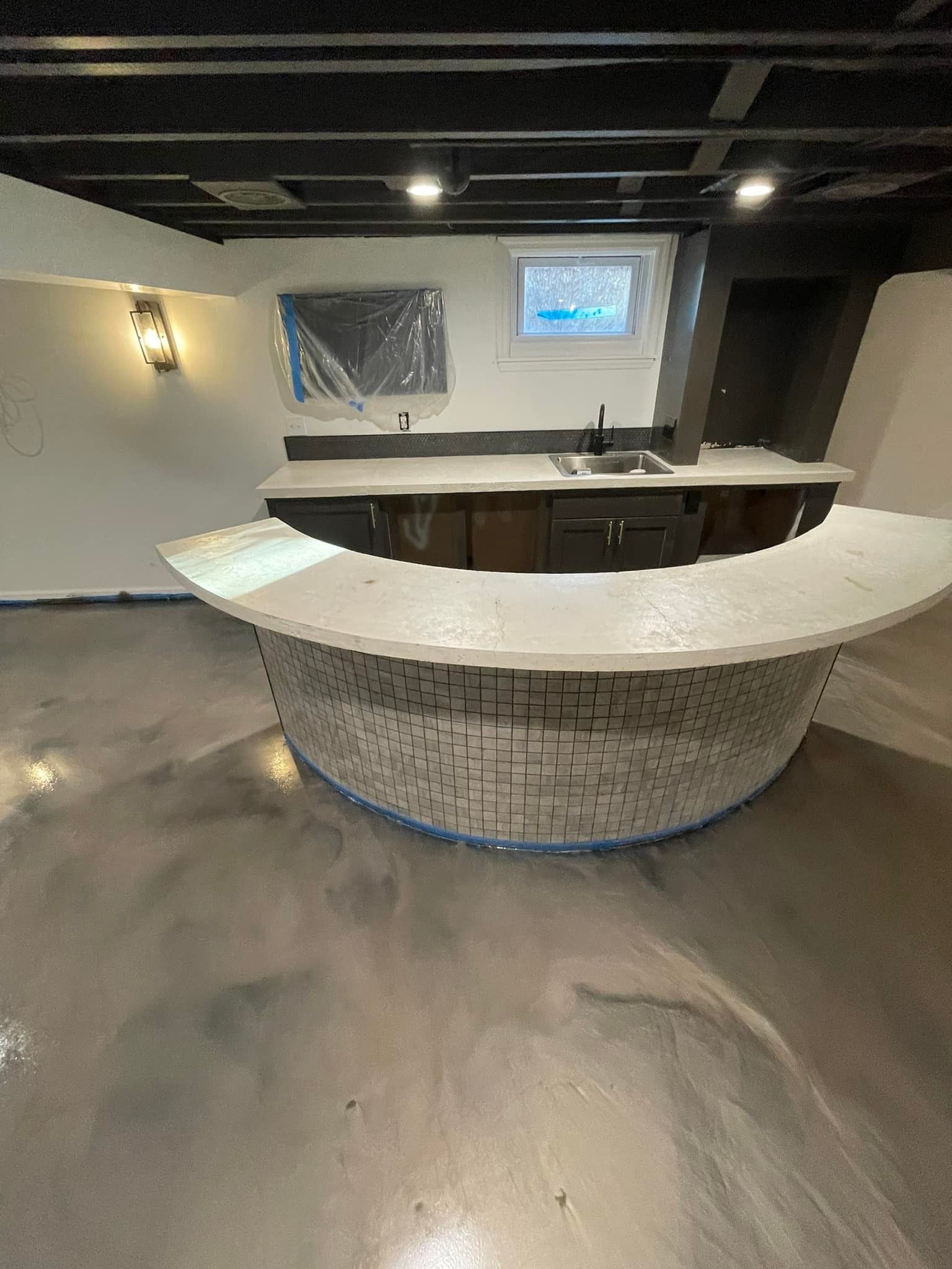 A kitchen with a curved counter top and a sink.