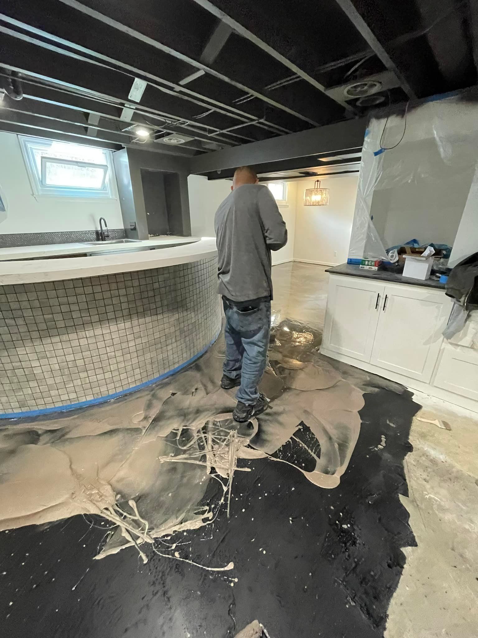 A man is standing in a room with a bar in the background.