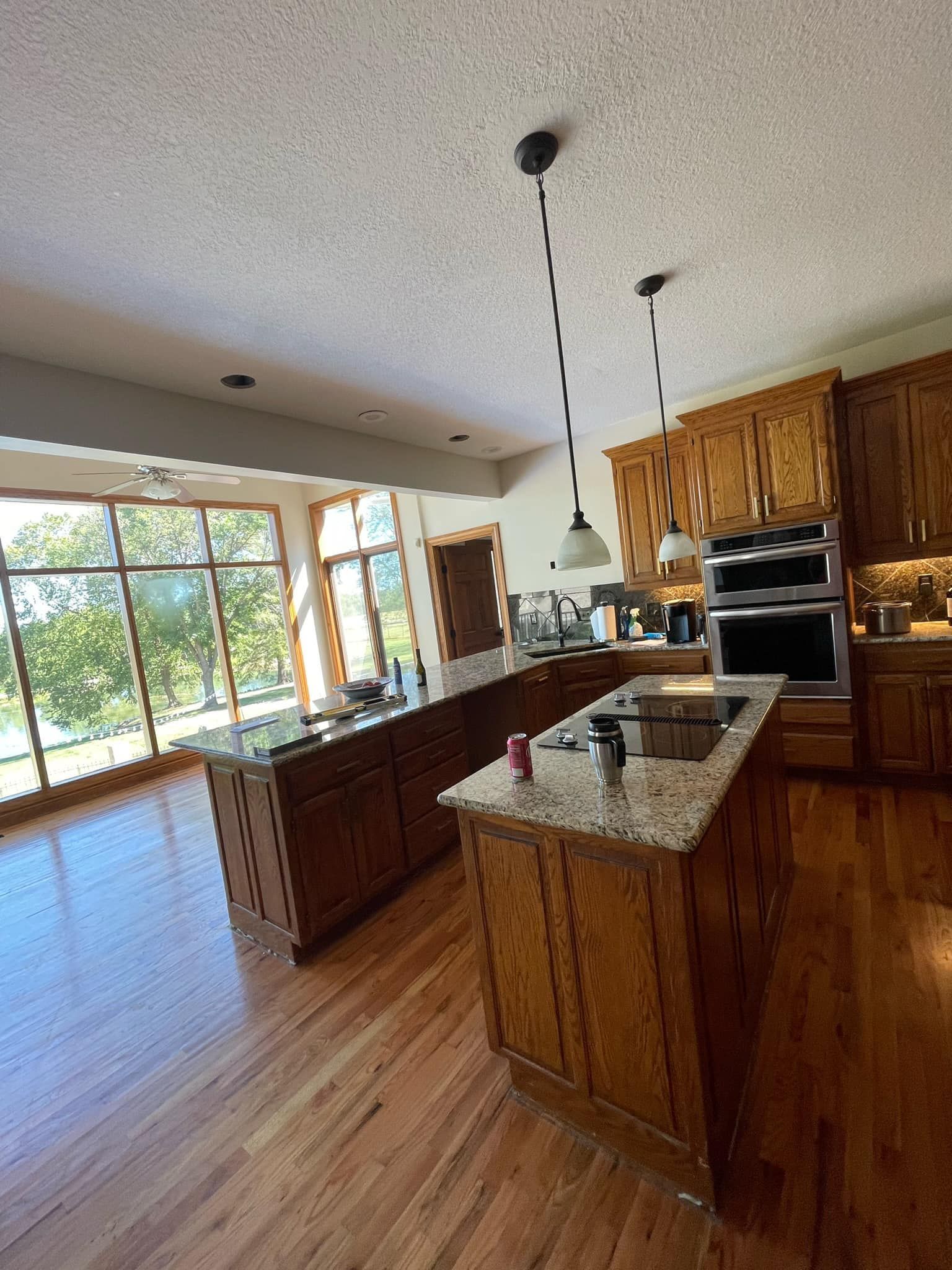 A kitchen with wooden cabinets , granite counter tops , and stainless steel appliances.