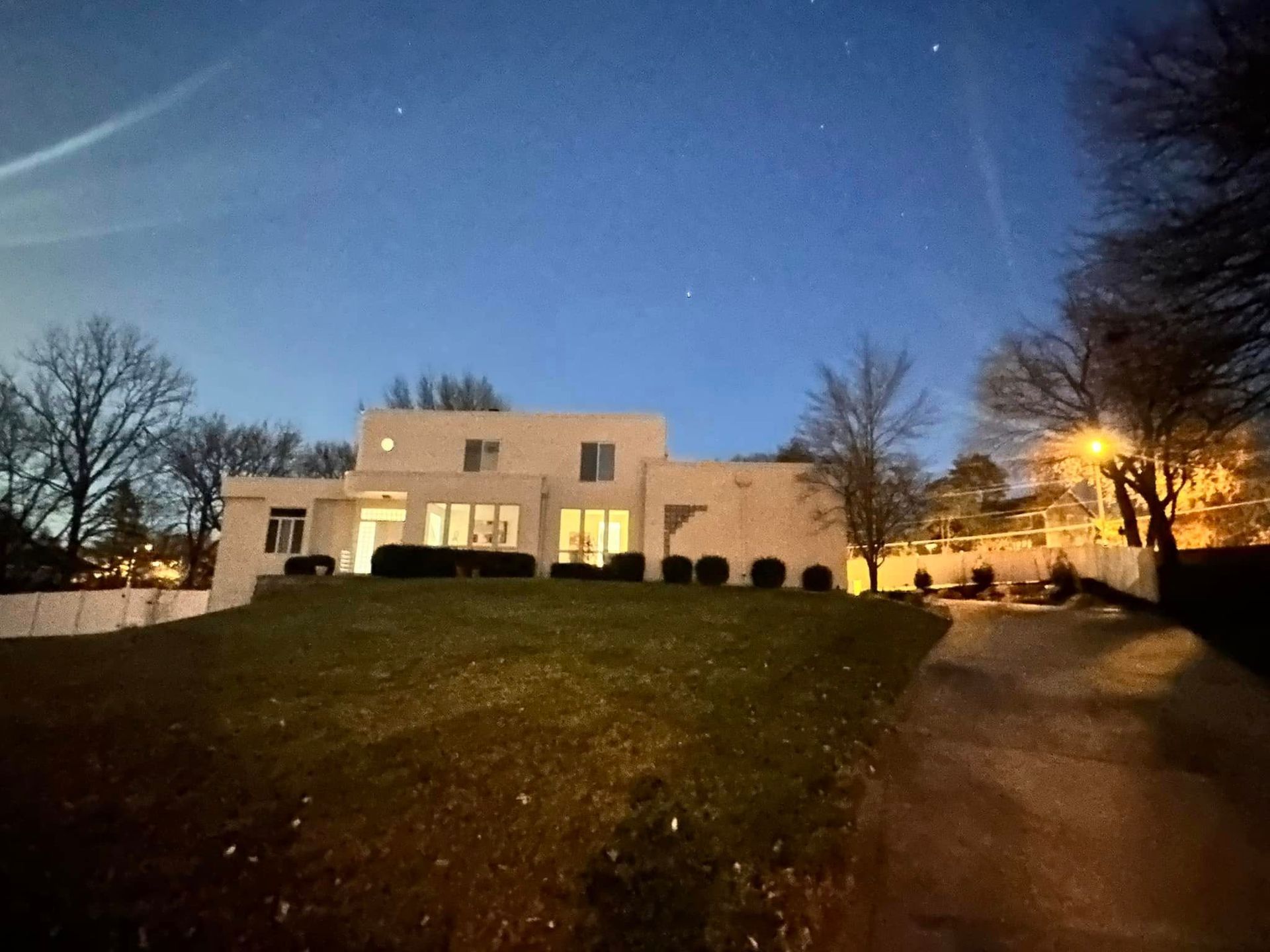 A large white house is lit up at night.