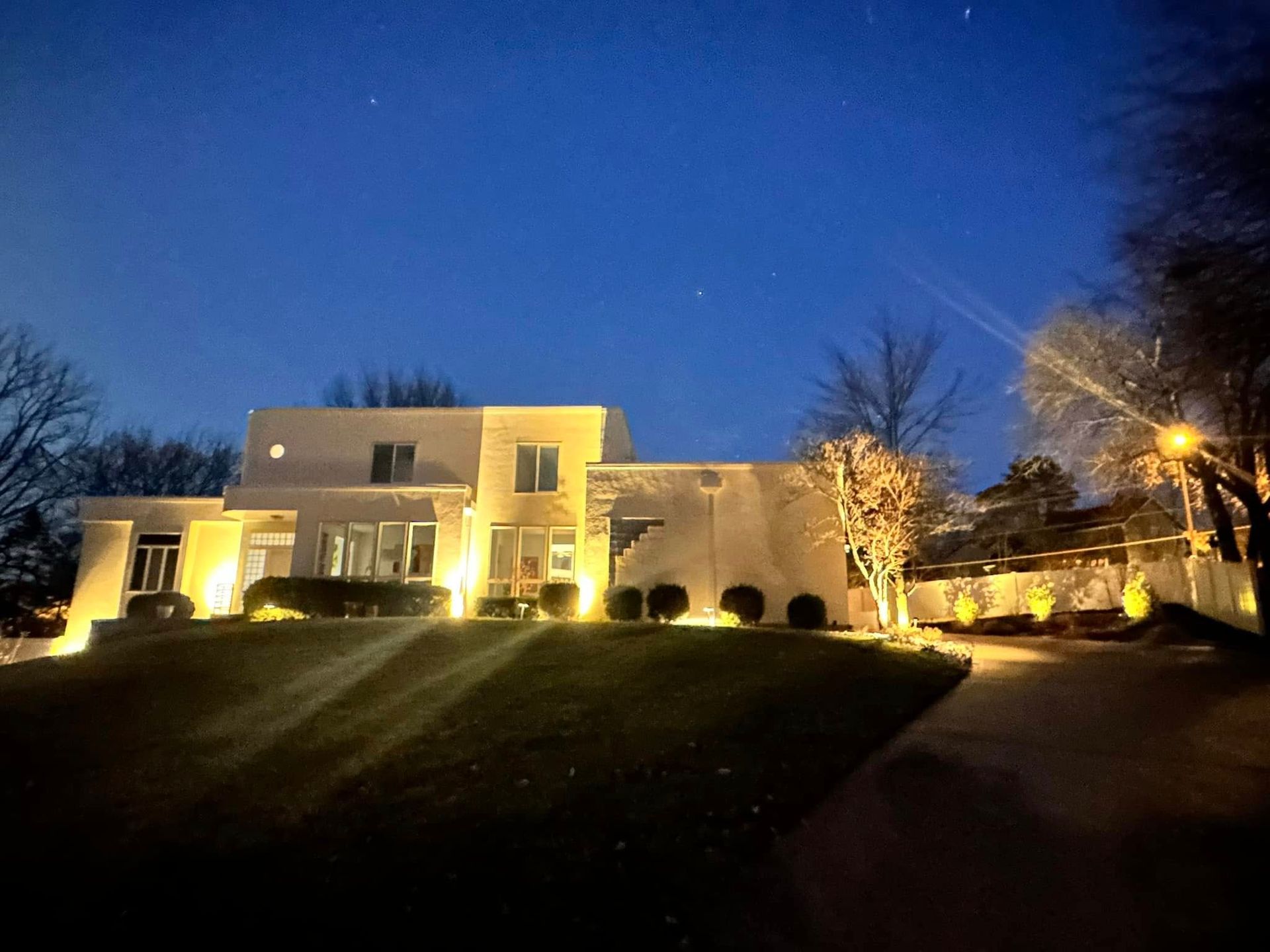 A large white house is lit up at night