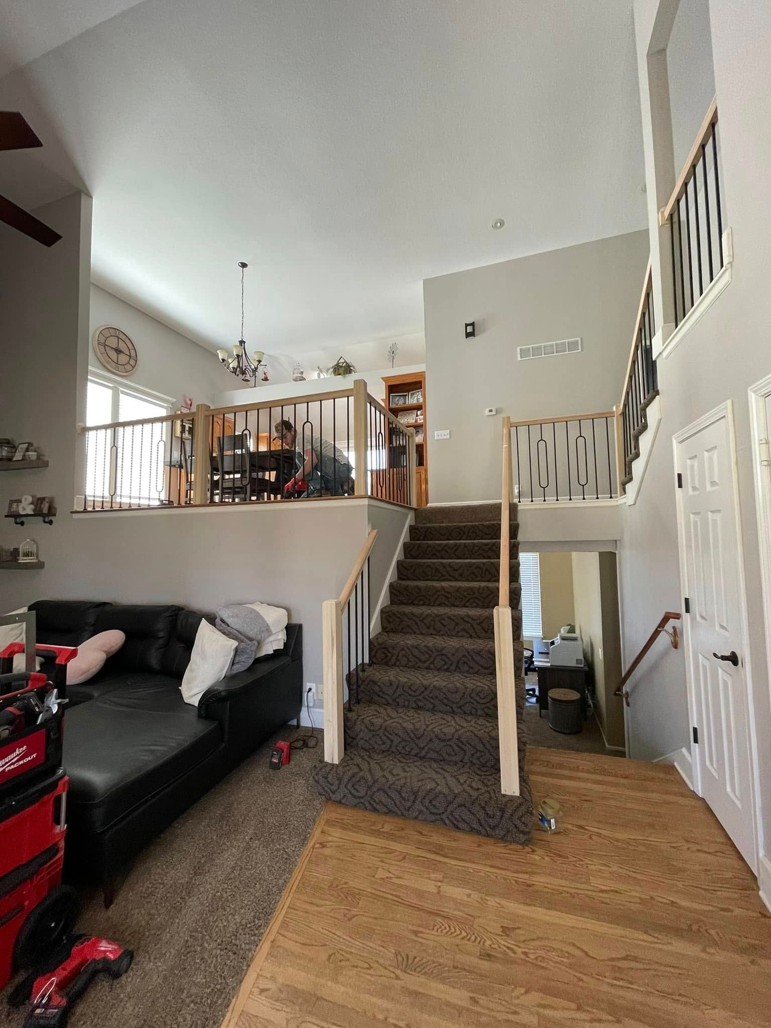A living room with a couch and stairs leading up to the second floor.
