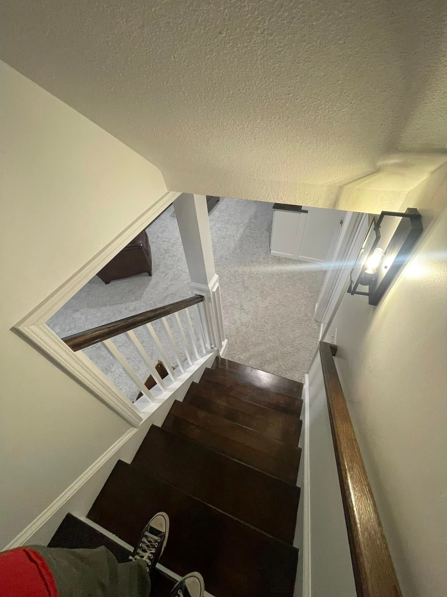A person is walking down a set of stairs in a house.