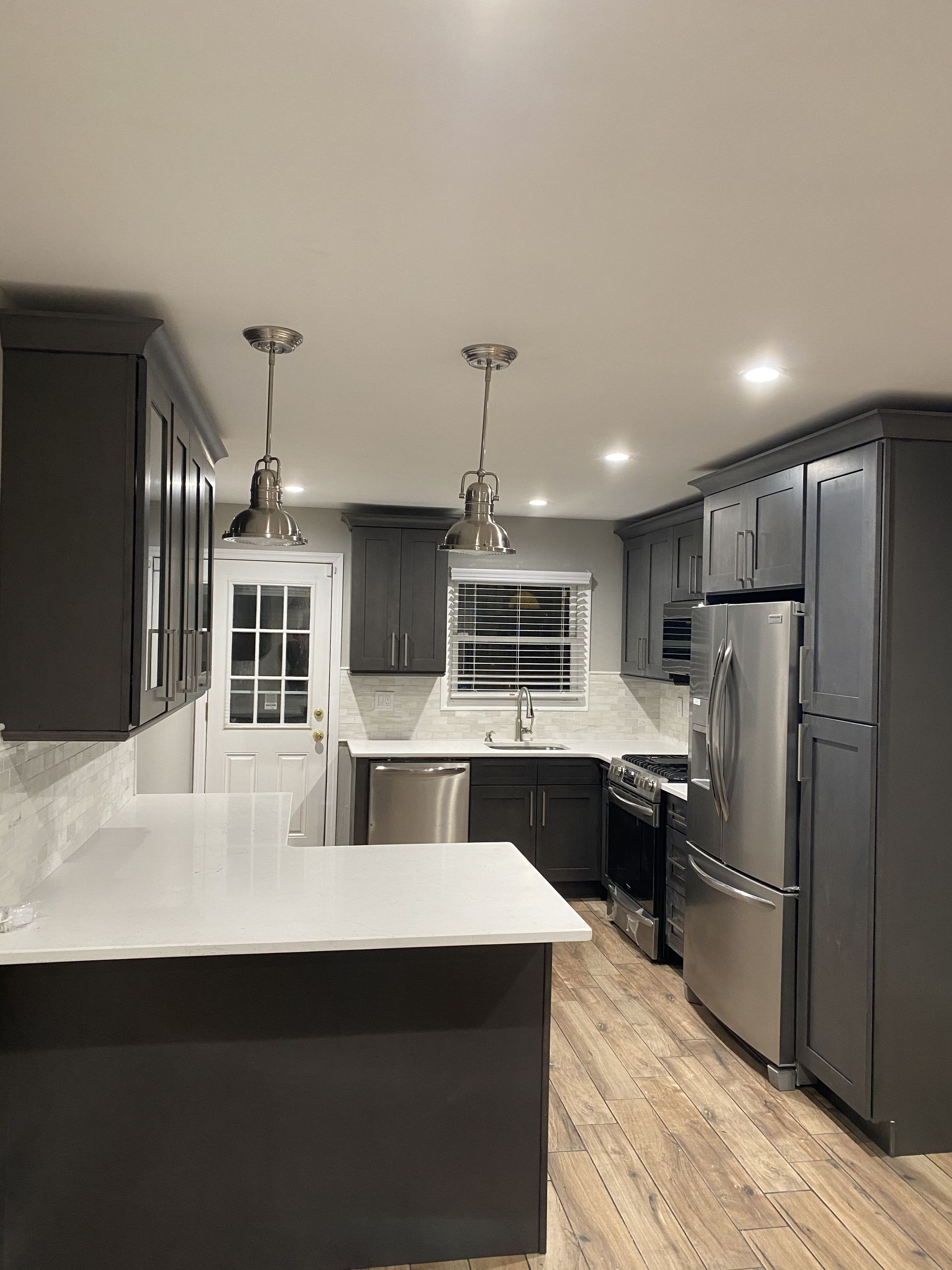 A kitchen with stainless steel appliances and gray cabinets