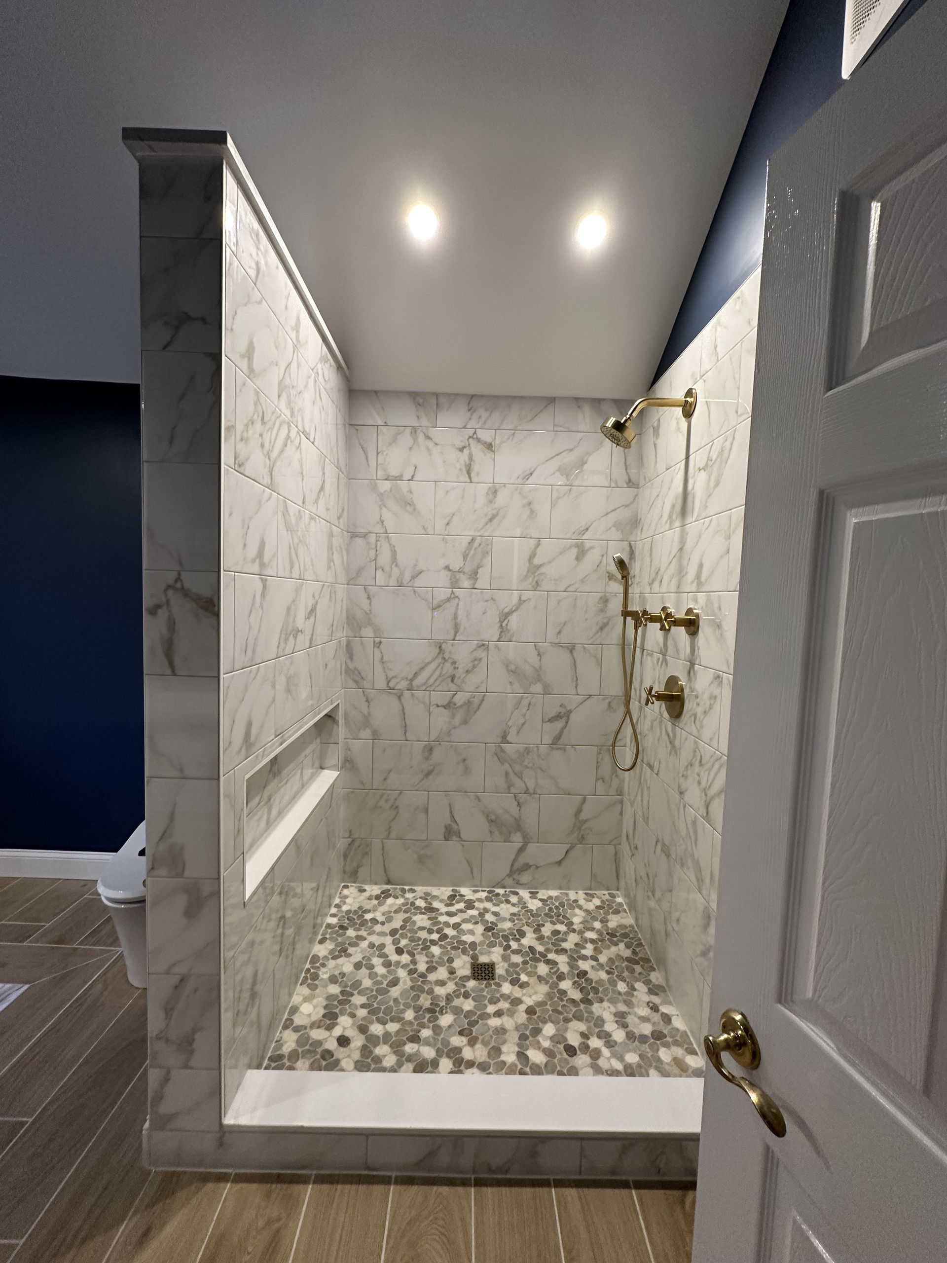A bathroom with a walk-in shower and a door.
