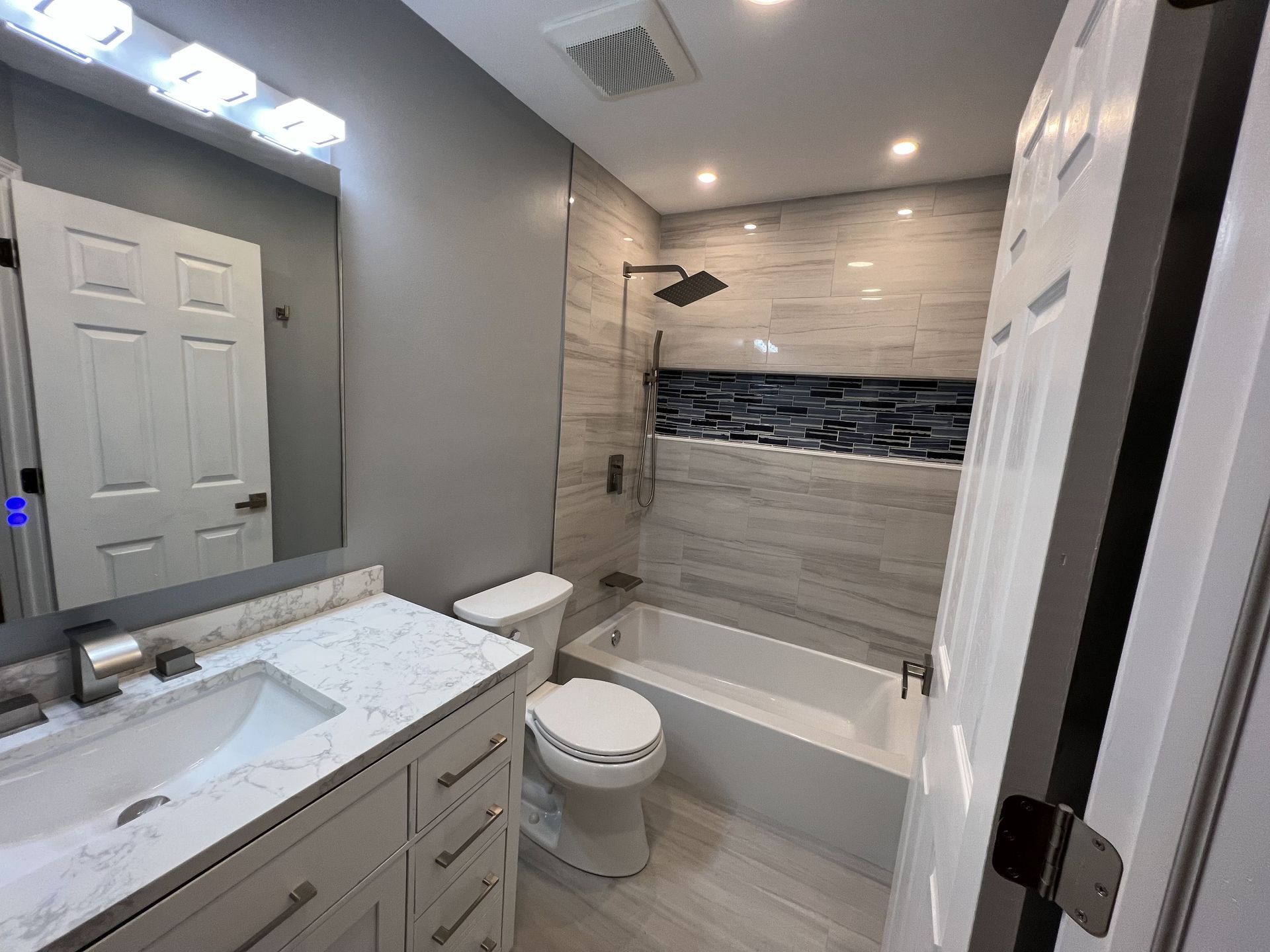 A bathroom with a toilet, sink, and bathtub.