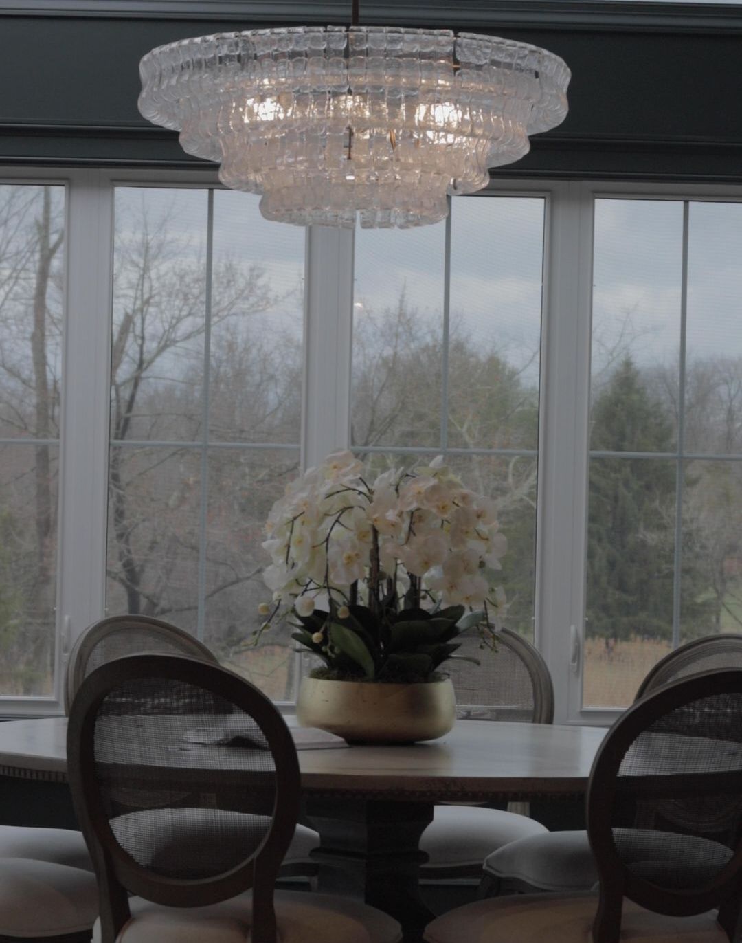 A dining room table with a vase of flowers on it
