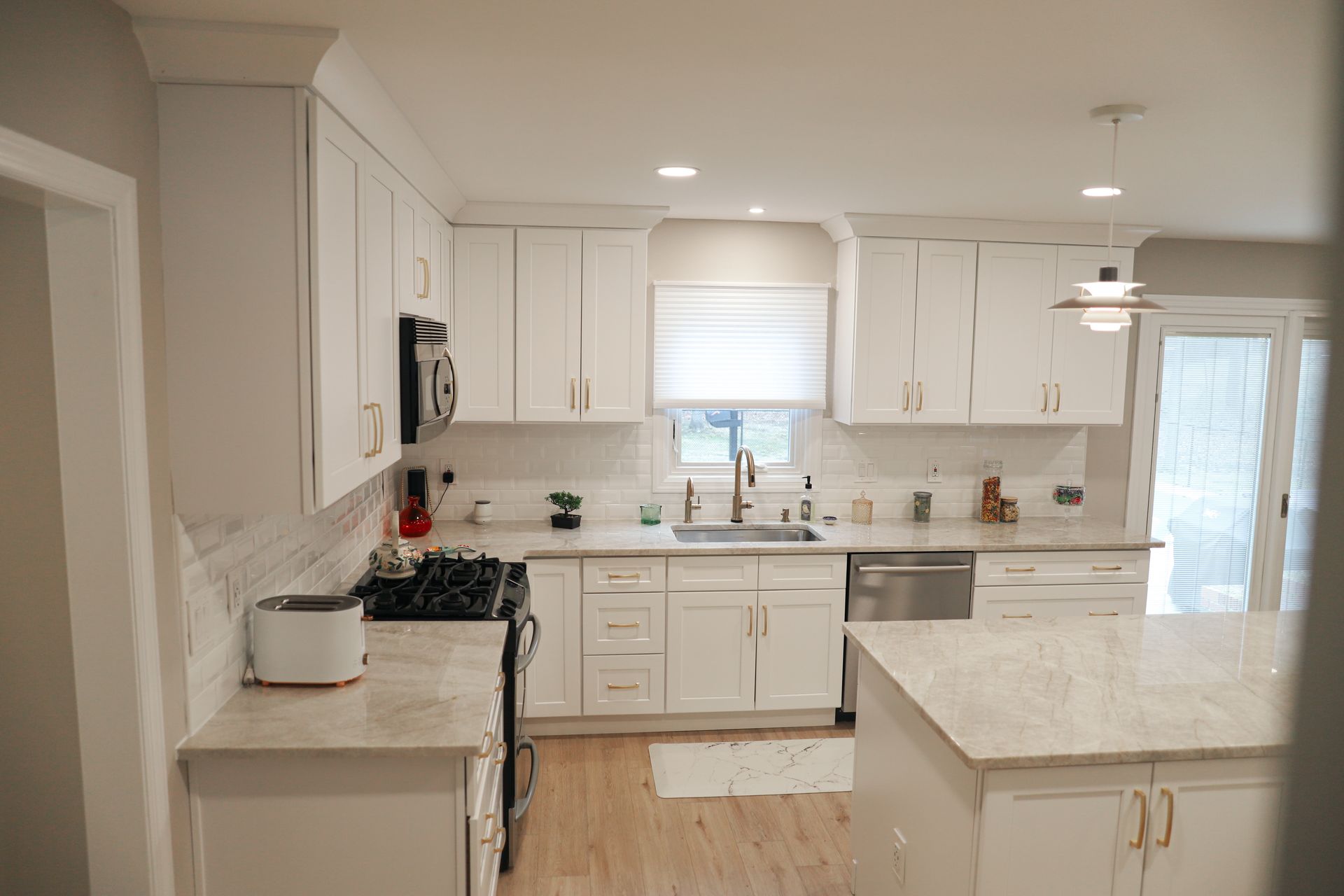 A kitchen with white cabinets and stainless steel appliances.