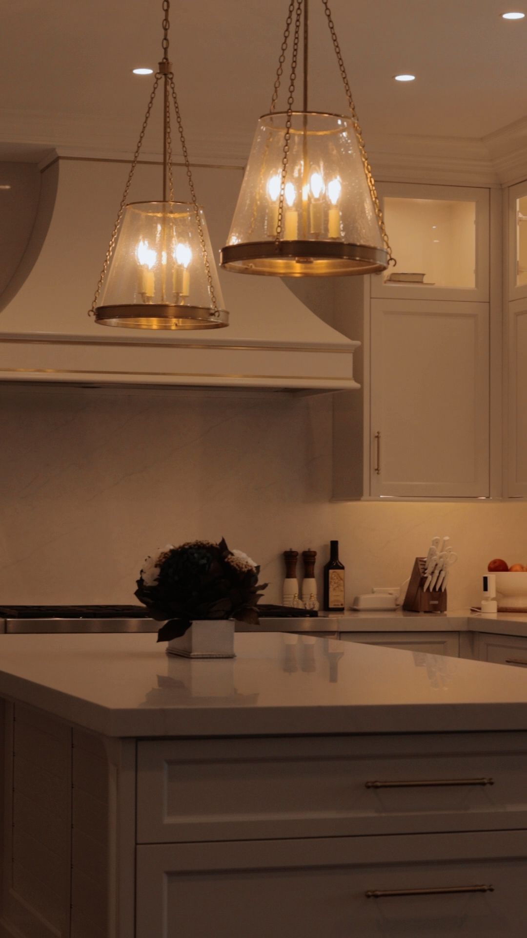 A kitchen with two pendant lights hanging from the ceiling above a counter.