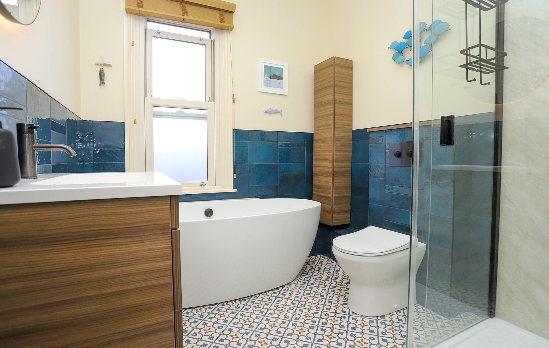 A bathroom with blue tiles and a white tub