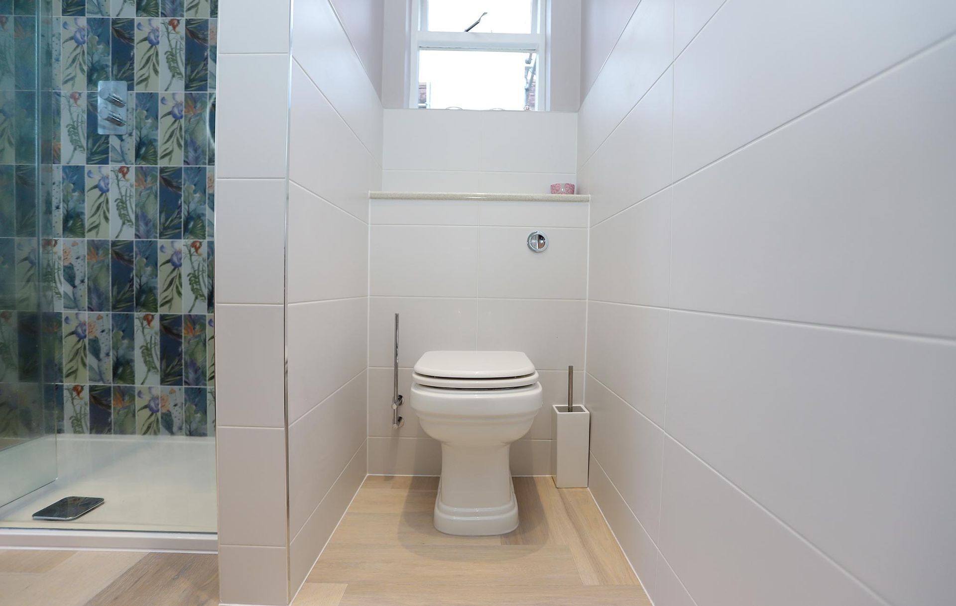 A toilet is sitting in a bathroom next to a shower.
