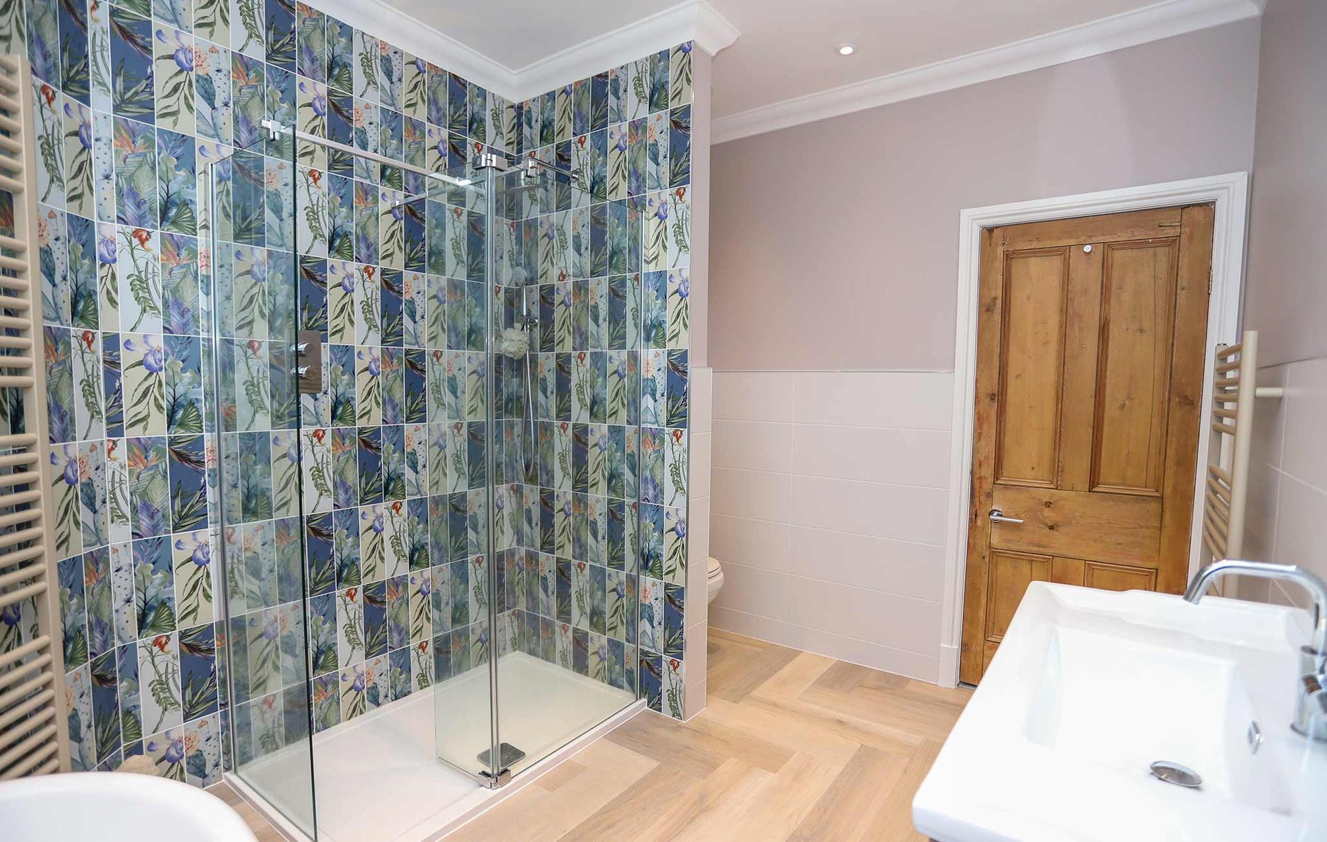 A bathroom with a walk in shower and a sink