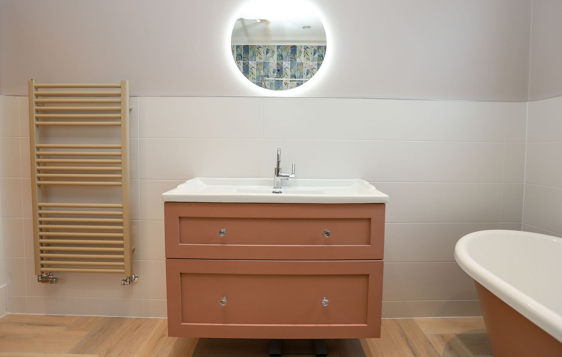 A bathroom with a sink , bathtub , towel rack and mirror.