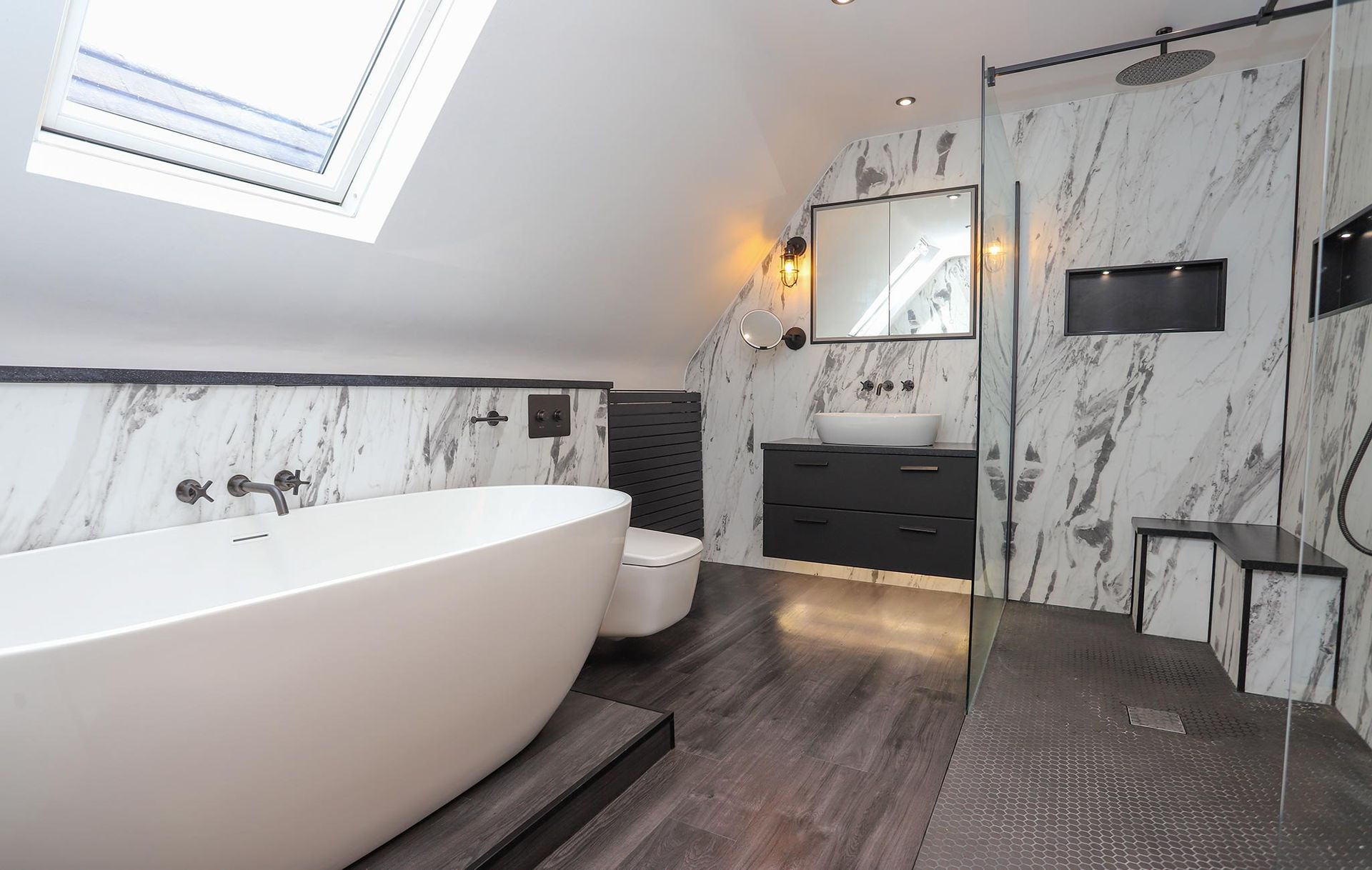 A bathroom with a bathtub , toilet , sink and shower.