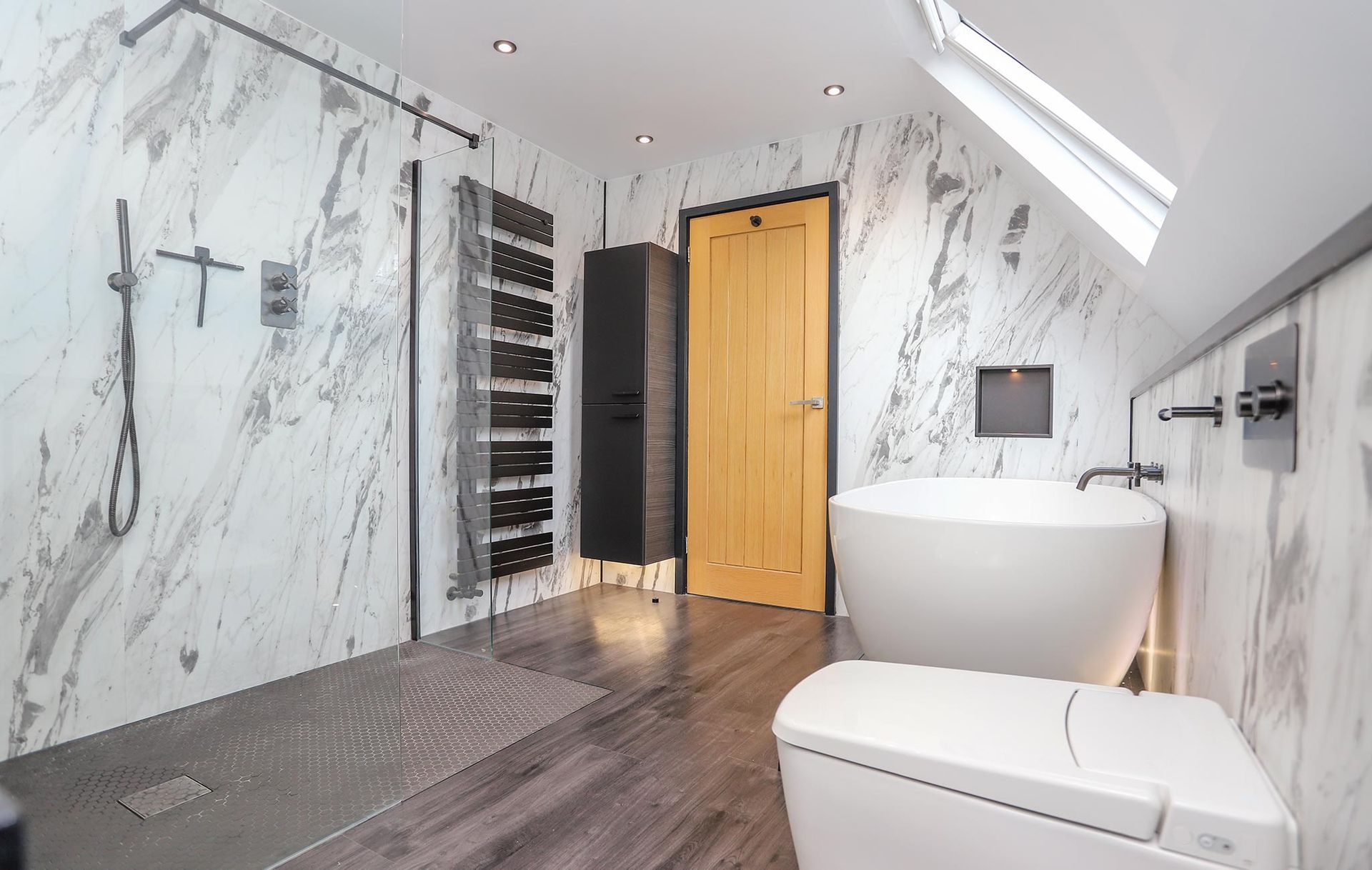 A bathroom with a tub , toilet and shower