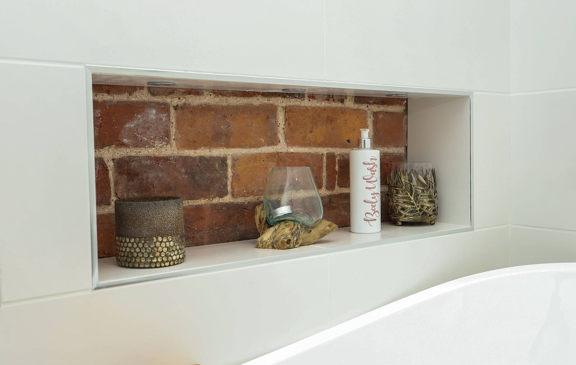 A bathroom with a brick wall and a shelf that says relax on it