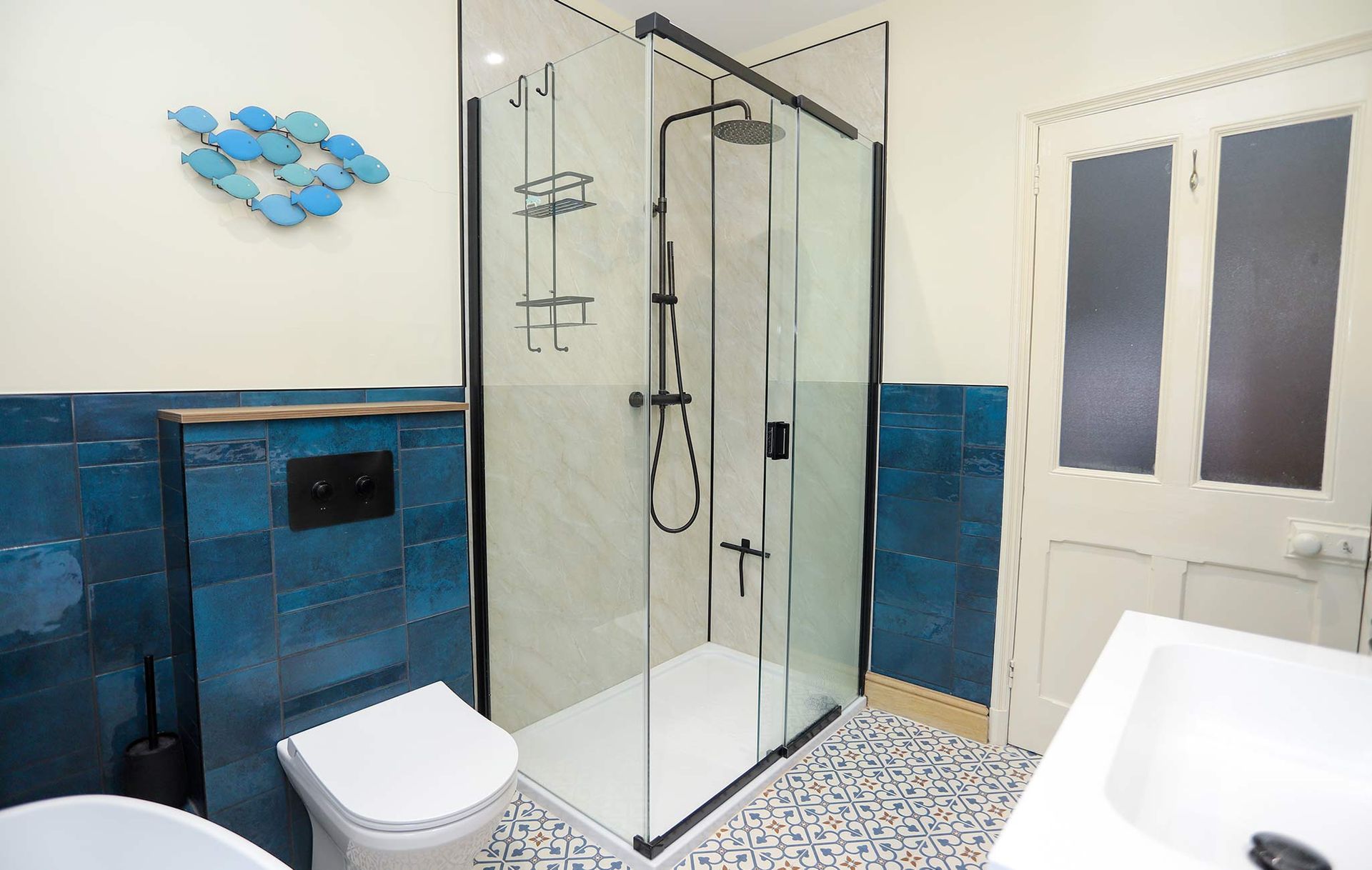 A bathroom with blue tiles and a walk in shower