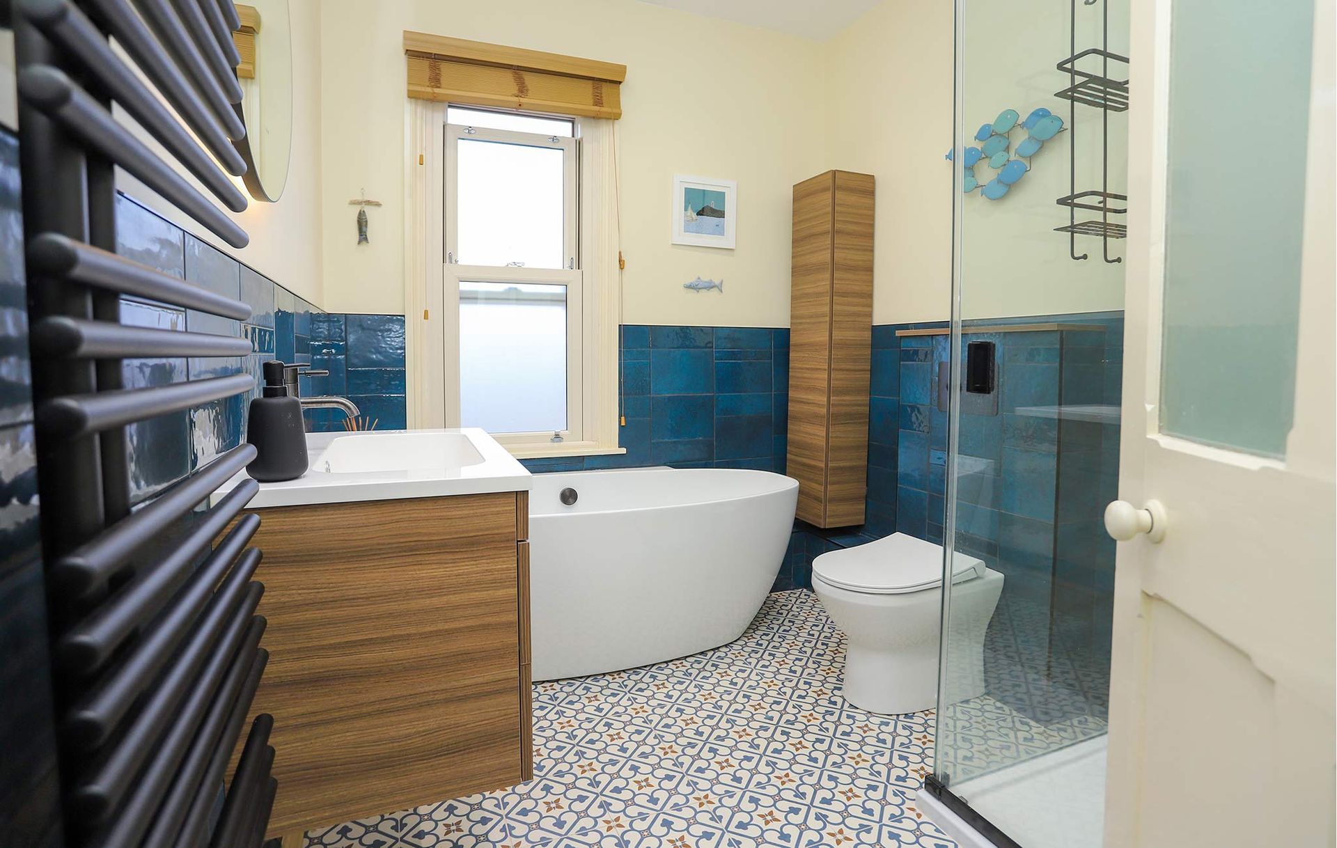 A bathroom with blue tiles and a white tub