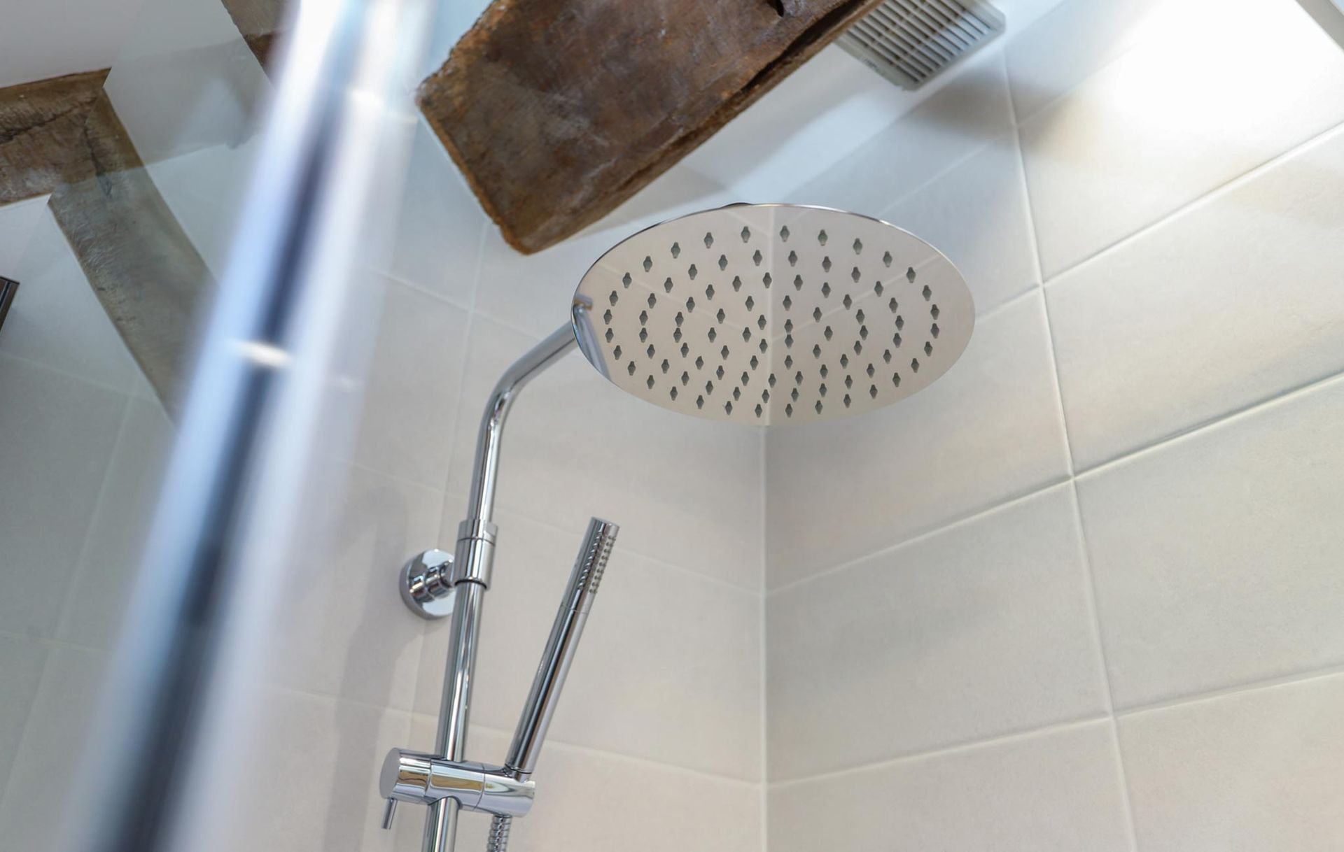 A close up of a shower head in a bathroom