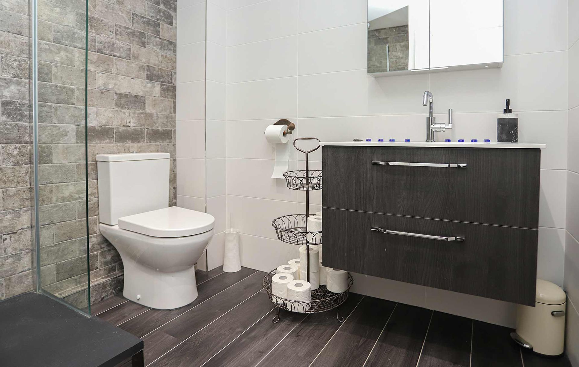 A bathroom with a toilet a sink and a mirror