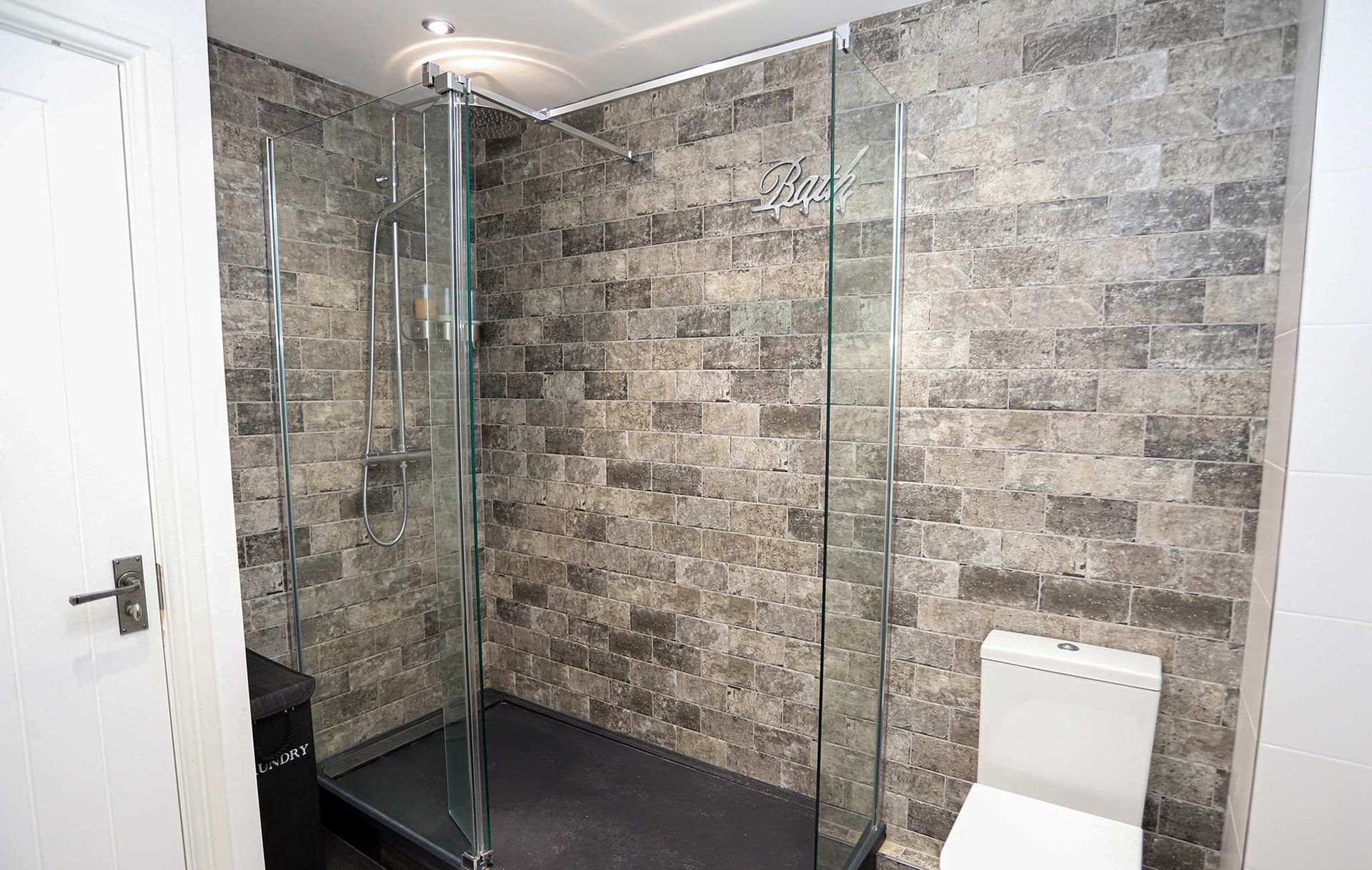 A bathroom with a walk in shower and a toilet