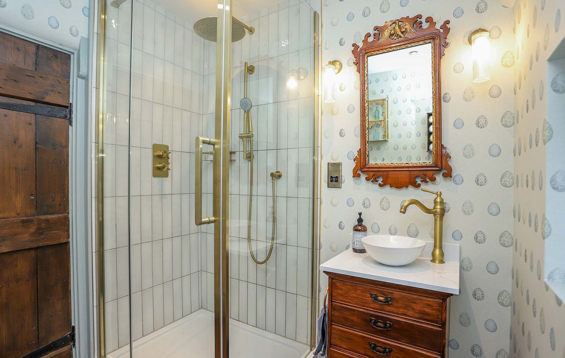 A bathroom with a walk in shower and a sink