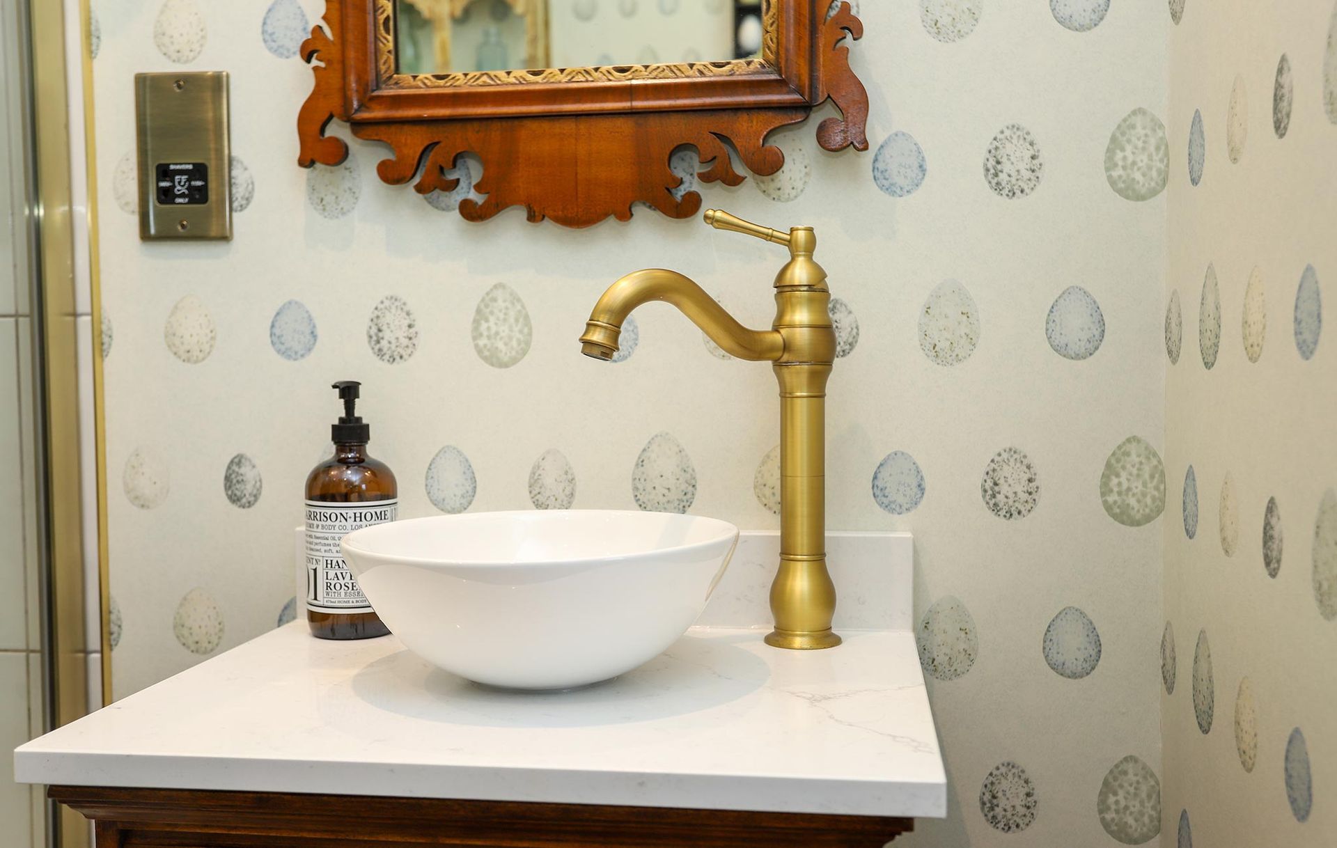 A bathroom with a sink a mirror and a soap dispenser