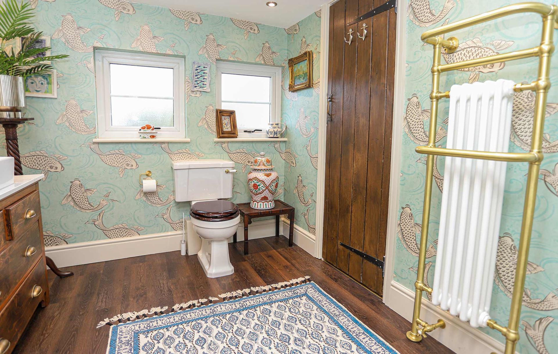 A bathroom with a toilet and a rug on the floor