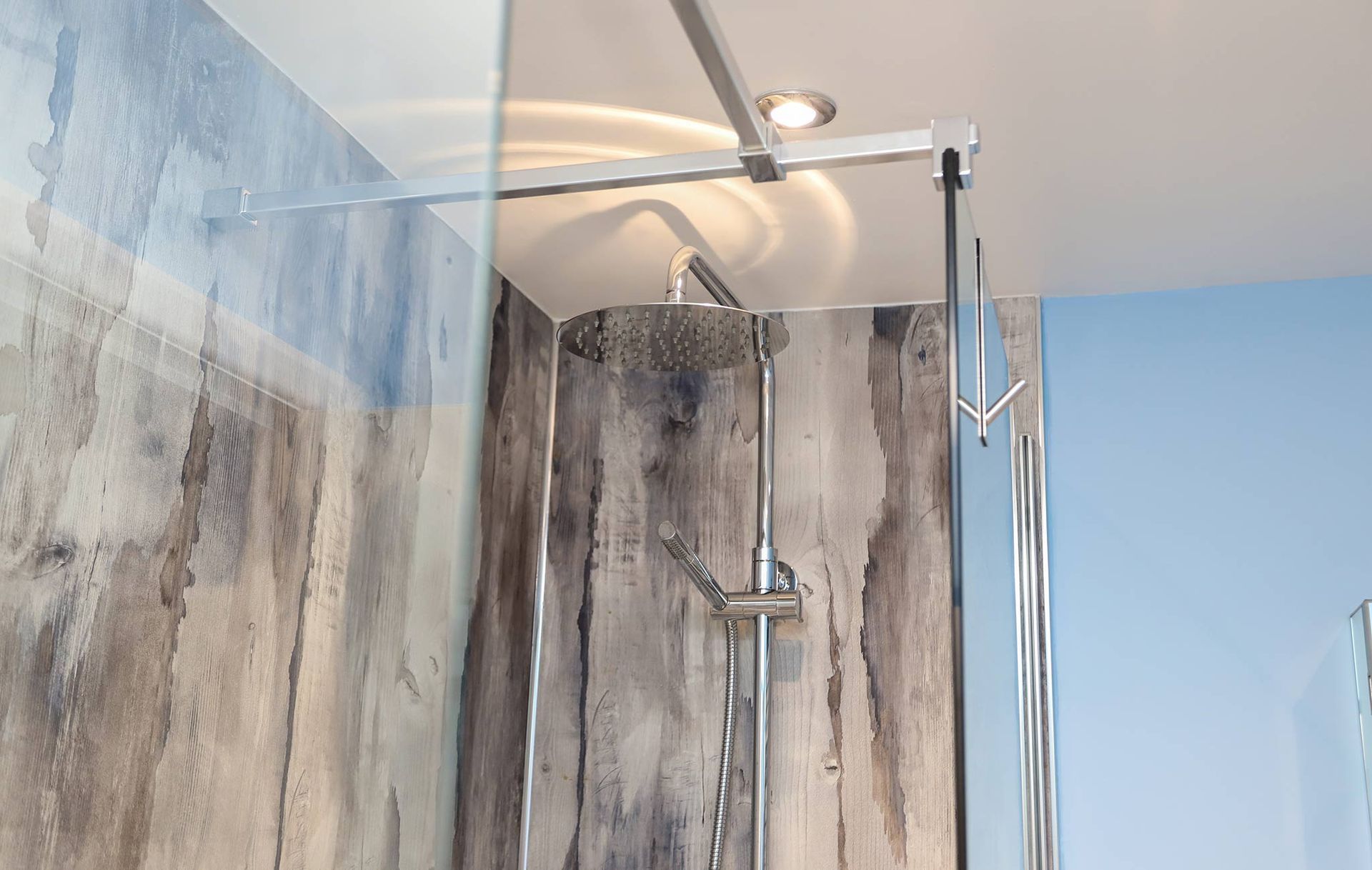 A bathroom with a shower and a blue wall