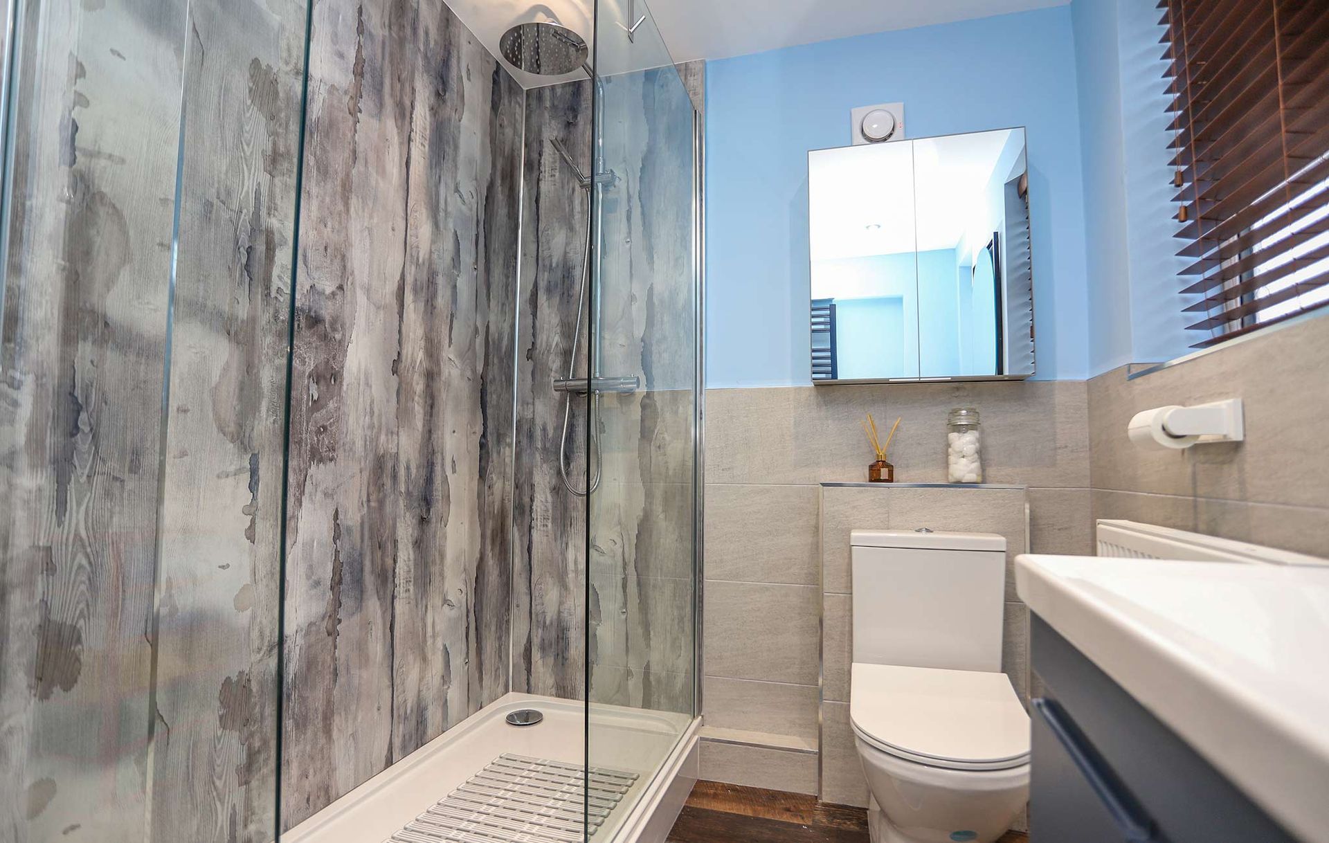 A bathroom with a toilet a sink and a shower