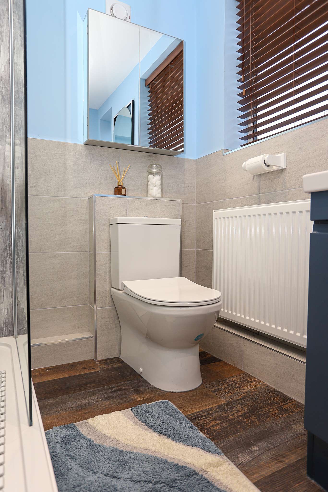 A bathroom with a toilet a sink and a mirror