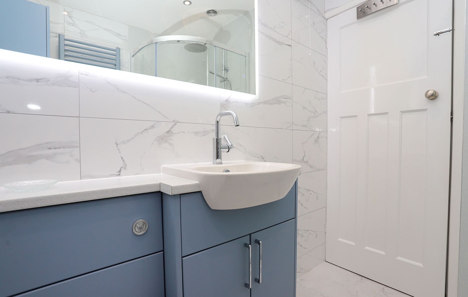 A bathroom with blue cabinets and a white sink
