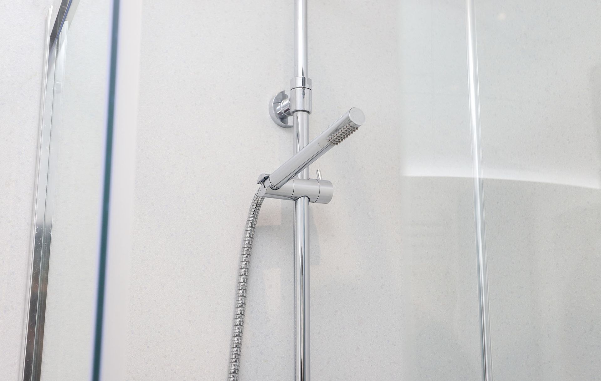 A close up of a shower head in a bathroom.