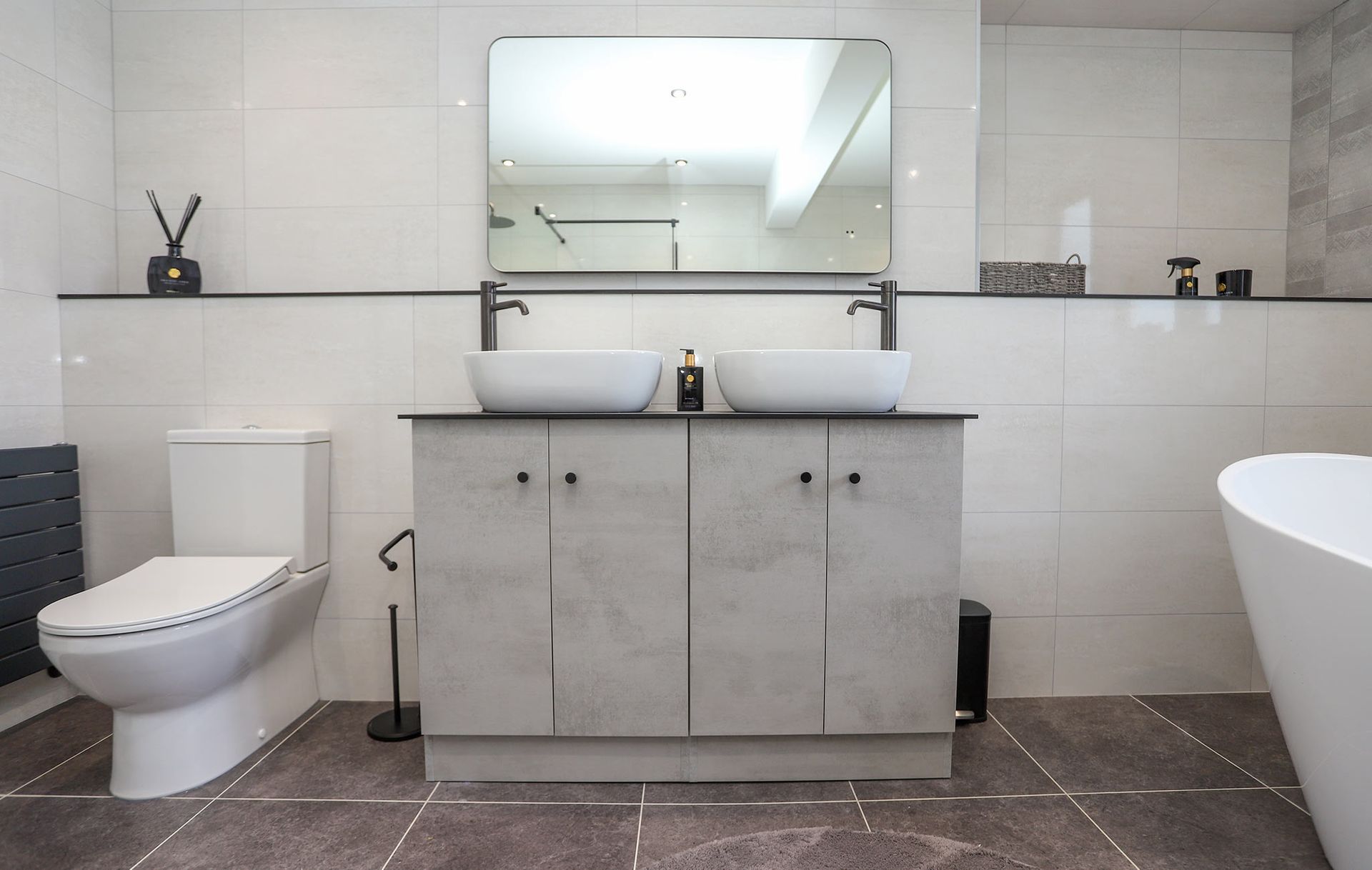 A bathroom with two sinks , a toilet , and a bathtub.