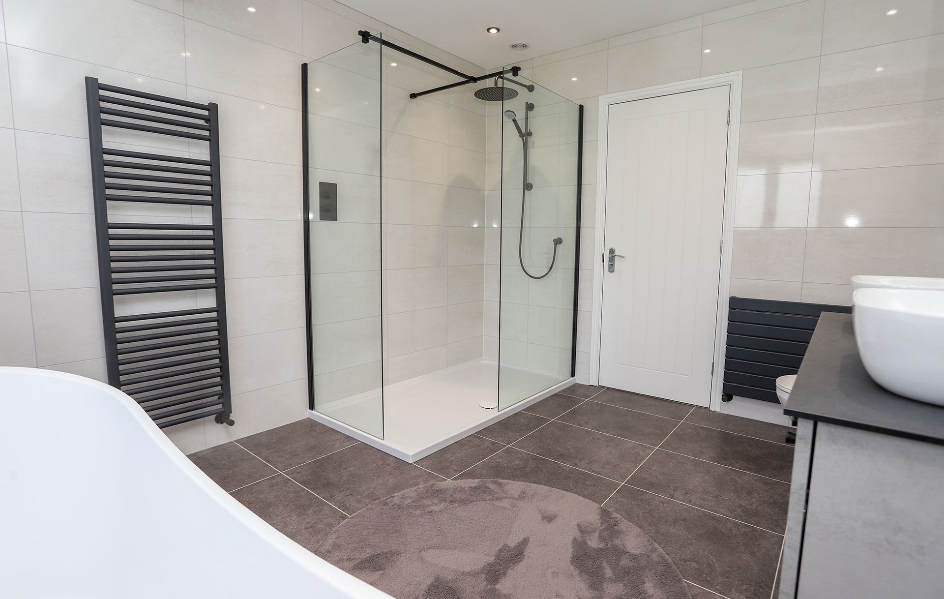 A bathroom with a walk in shower and a sink