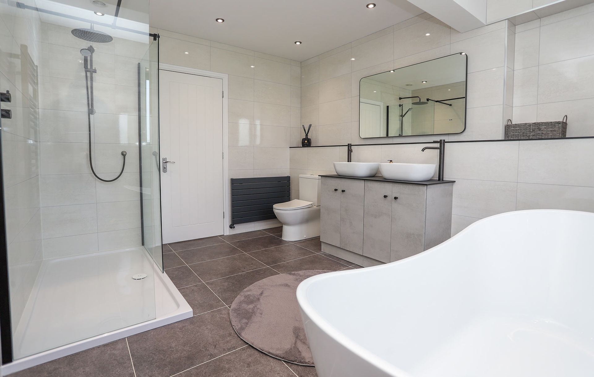 A bathroom with a bathtub , toilet , sinks and shower.