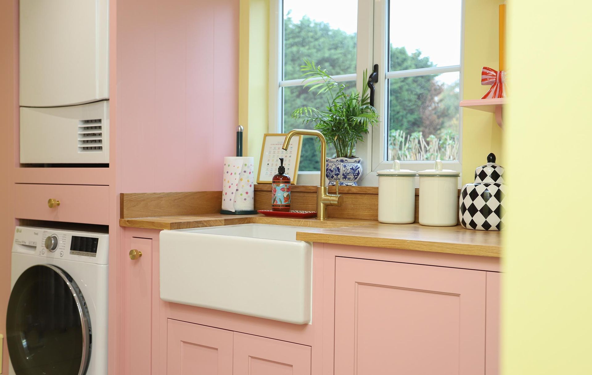 A kitchen with pink cabinets and a white sink