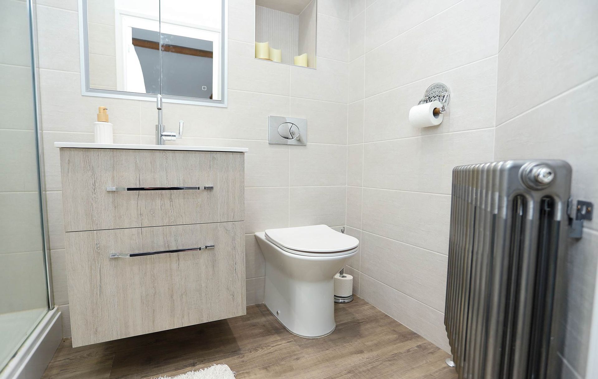 A bathroom with a toilet a sink and a radiator