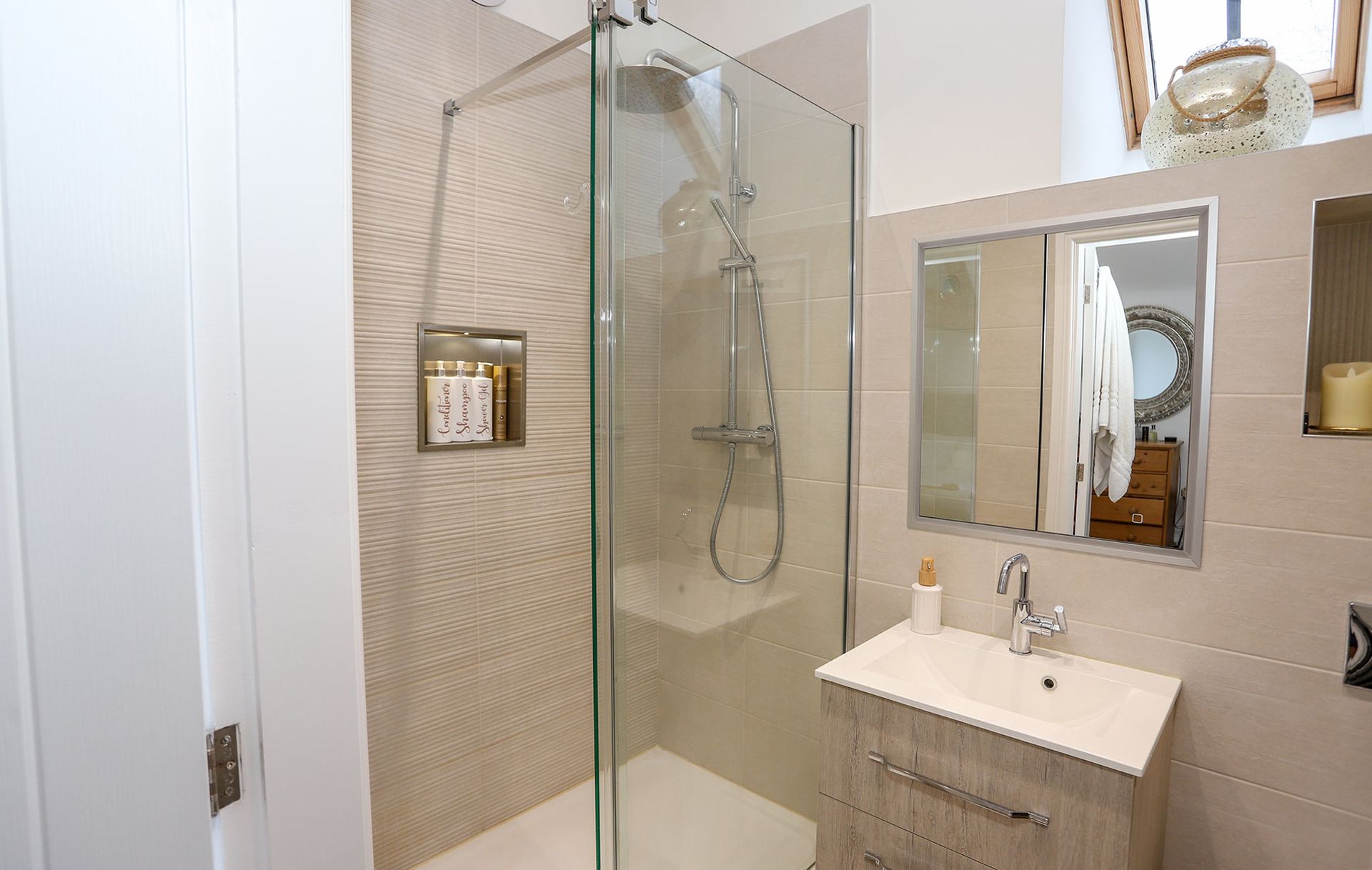 A bathroom with a walk in shower and a sink