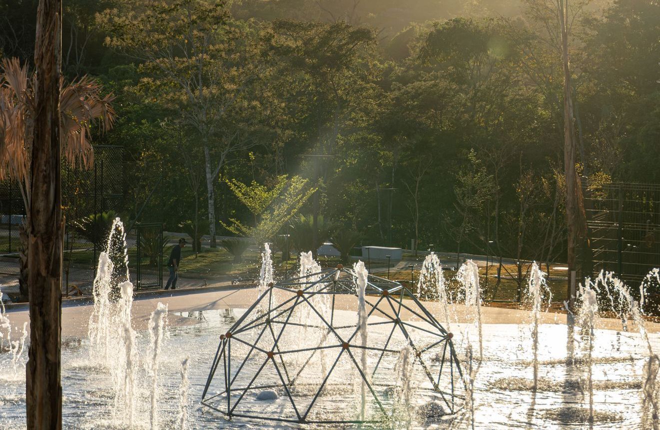 Uma mulher está agachada com uma barra nos ombros em uma academia.