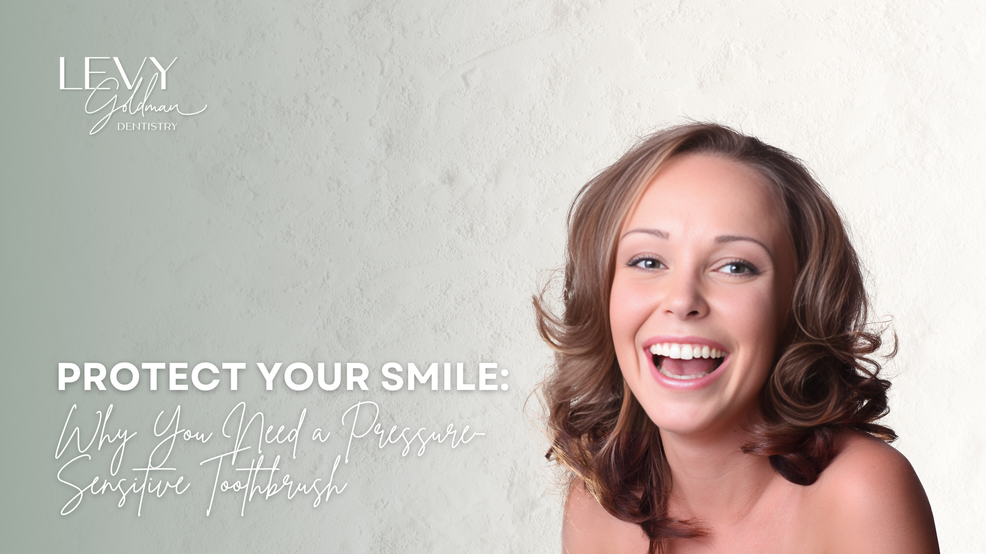 A woman is laughing with her mouth open in front of a white wall.